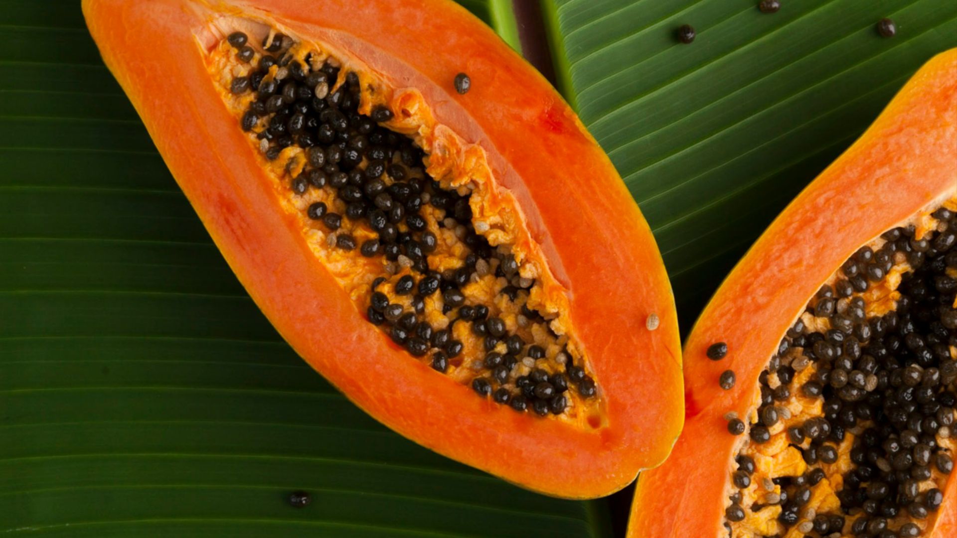 sliced papaya on green banana leaf