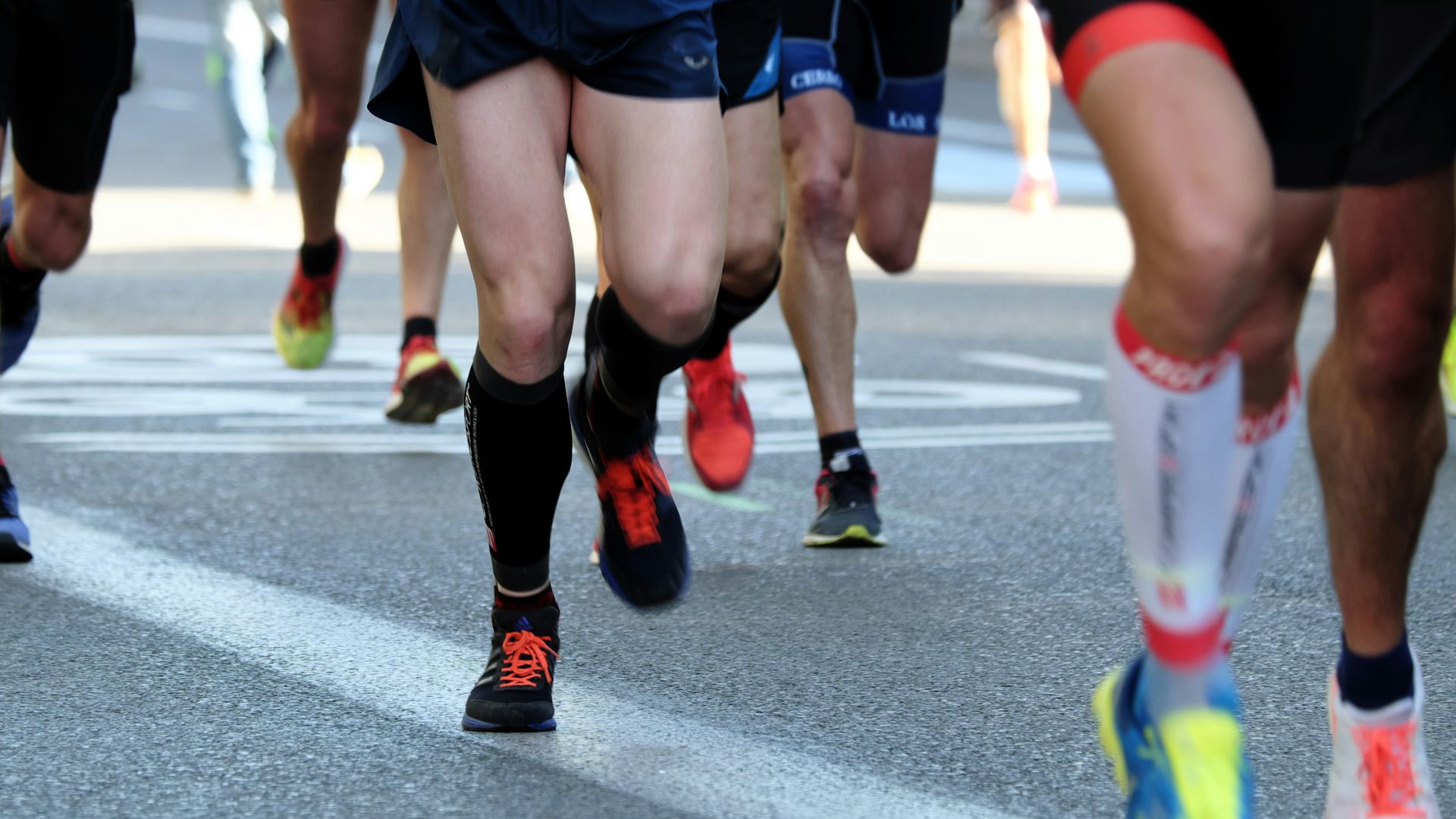 people running on gray asphalt road during daytime