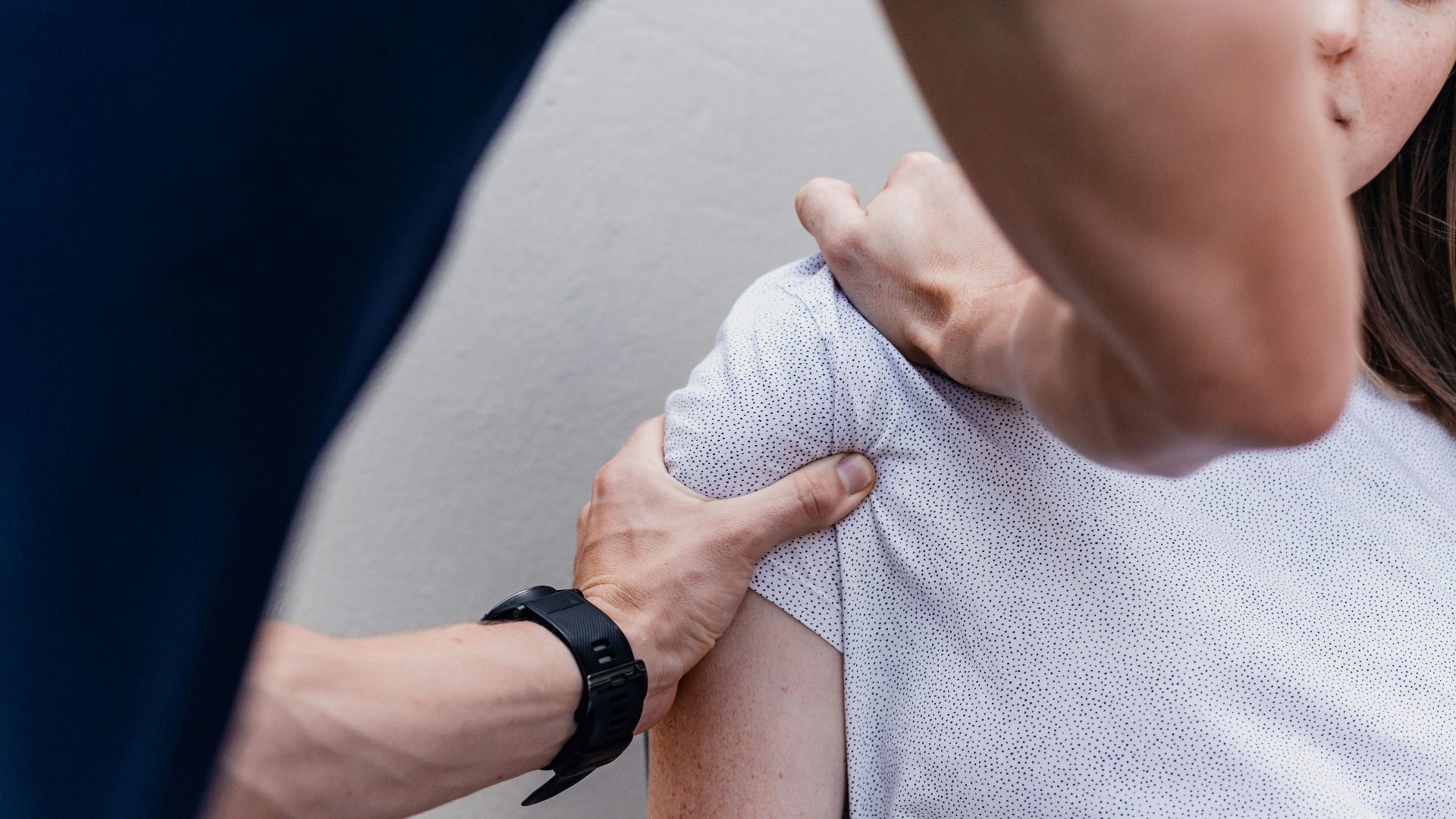 a woman holding onto a man's arm