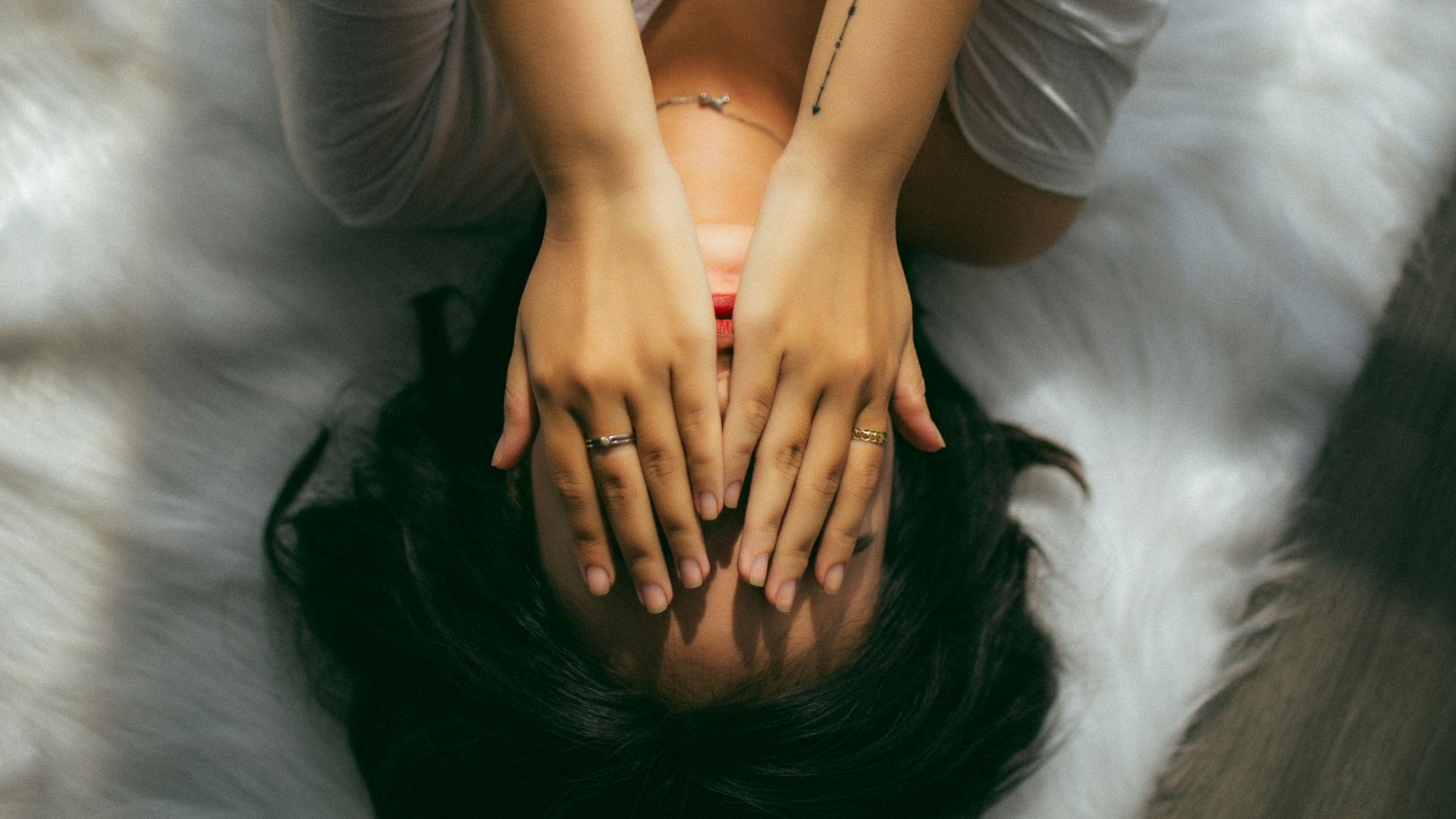 a woman holds her hands over her face