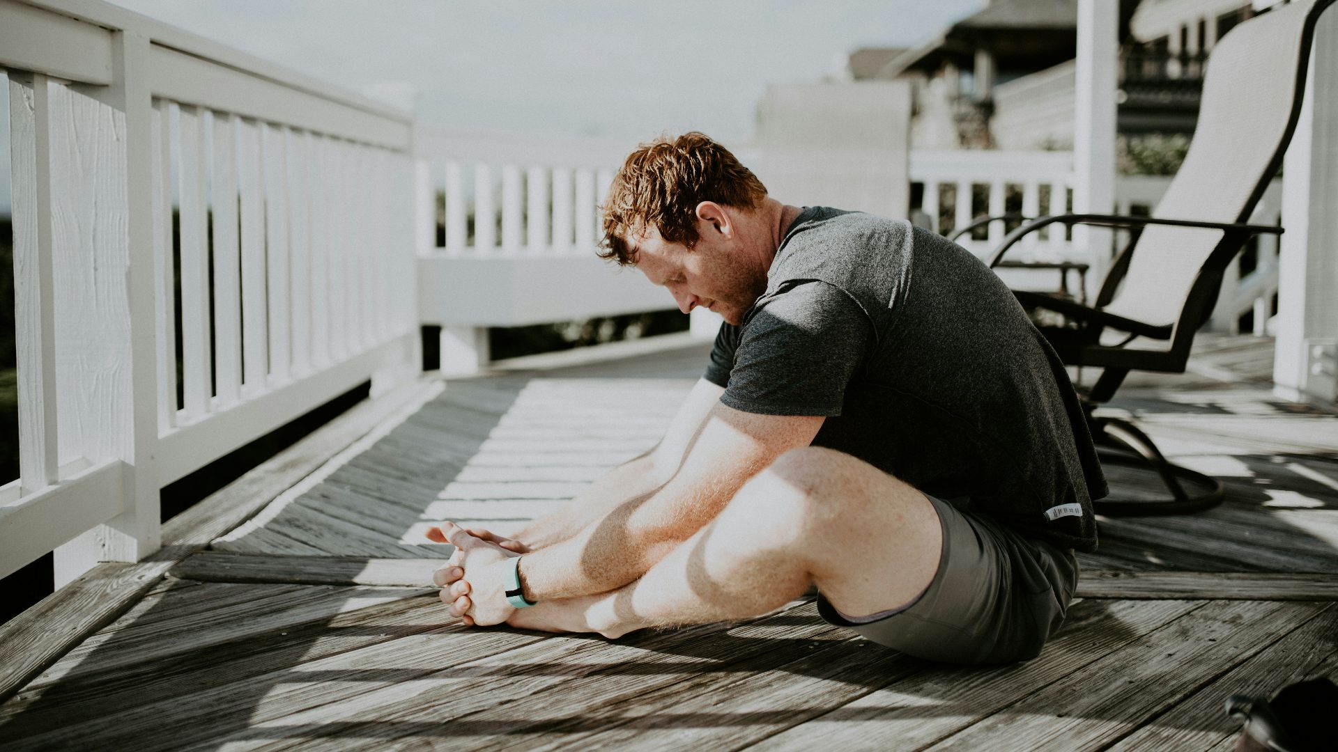 man doing yoga in porch