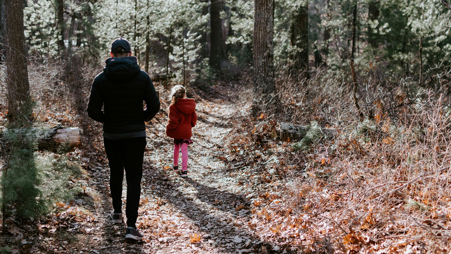 man in black jacket and black pants standing in the middle of forest during daytime