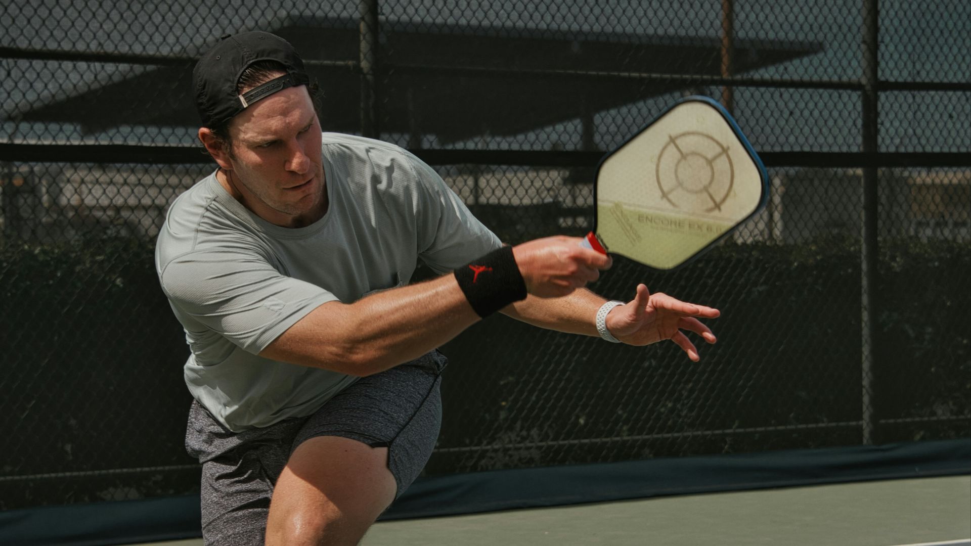 man in gray crew neck t-shirt and gray shorts sitting on basketball court