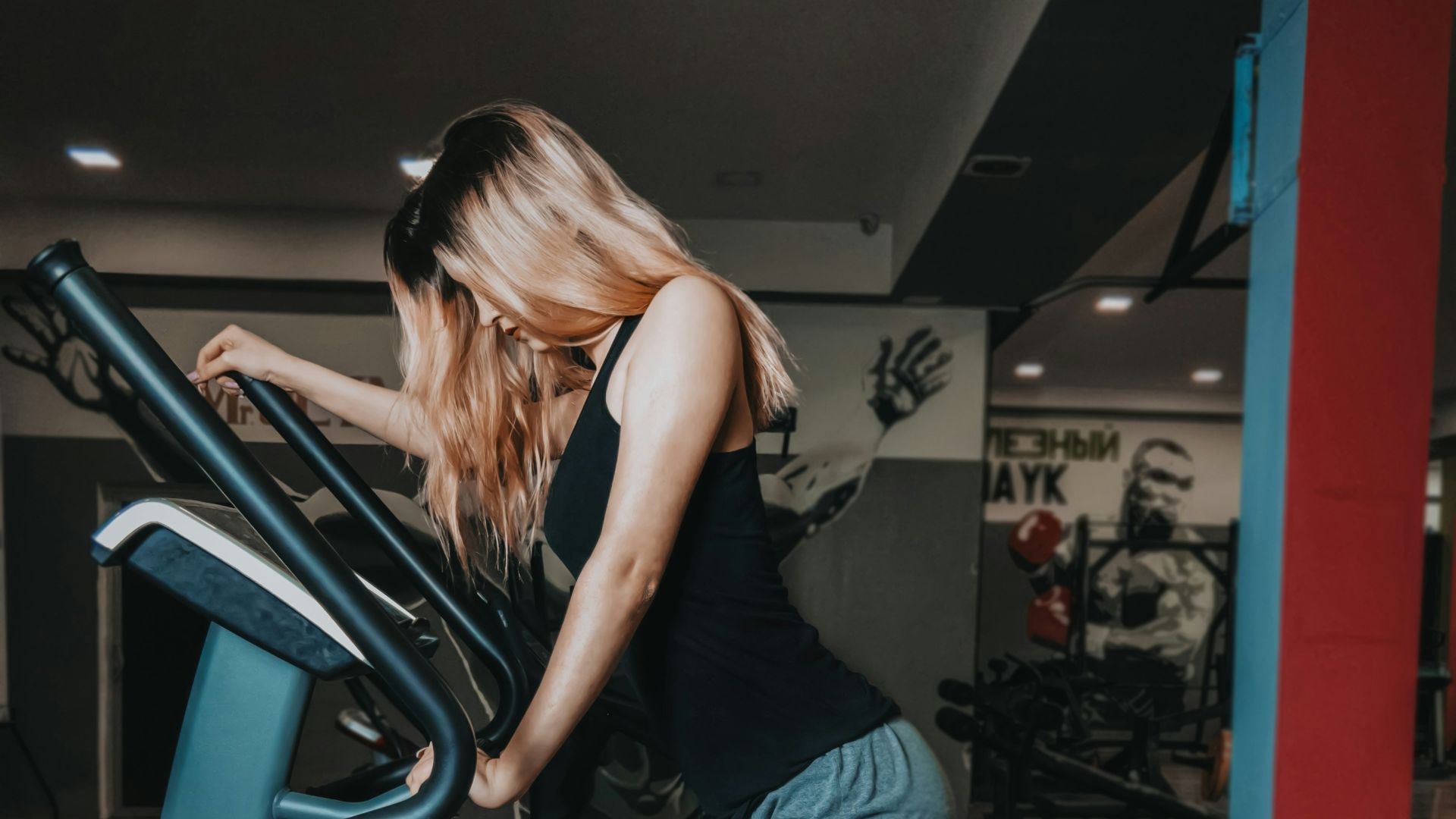 woman in black tank top and blue denim shorts standing on black metal staircase