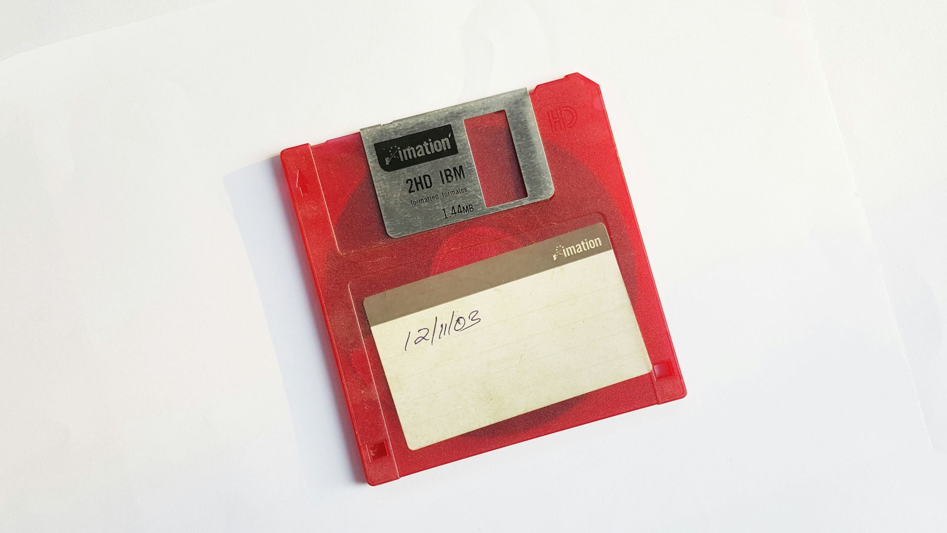 red and white floppy disk on white surface