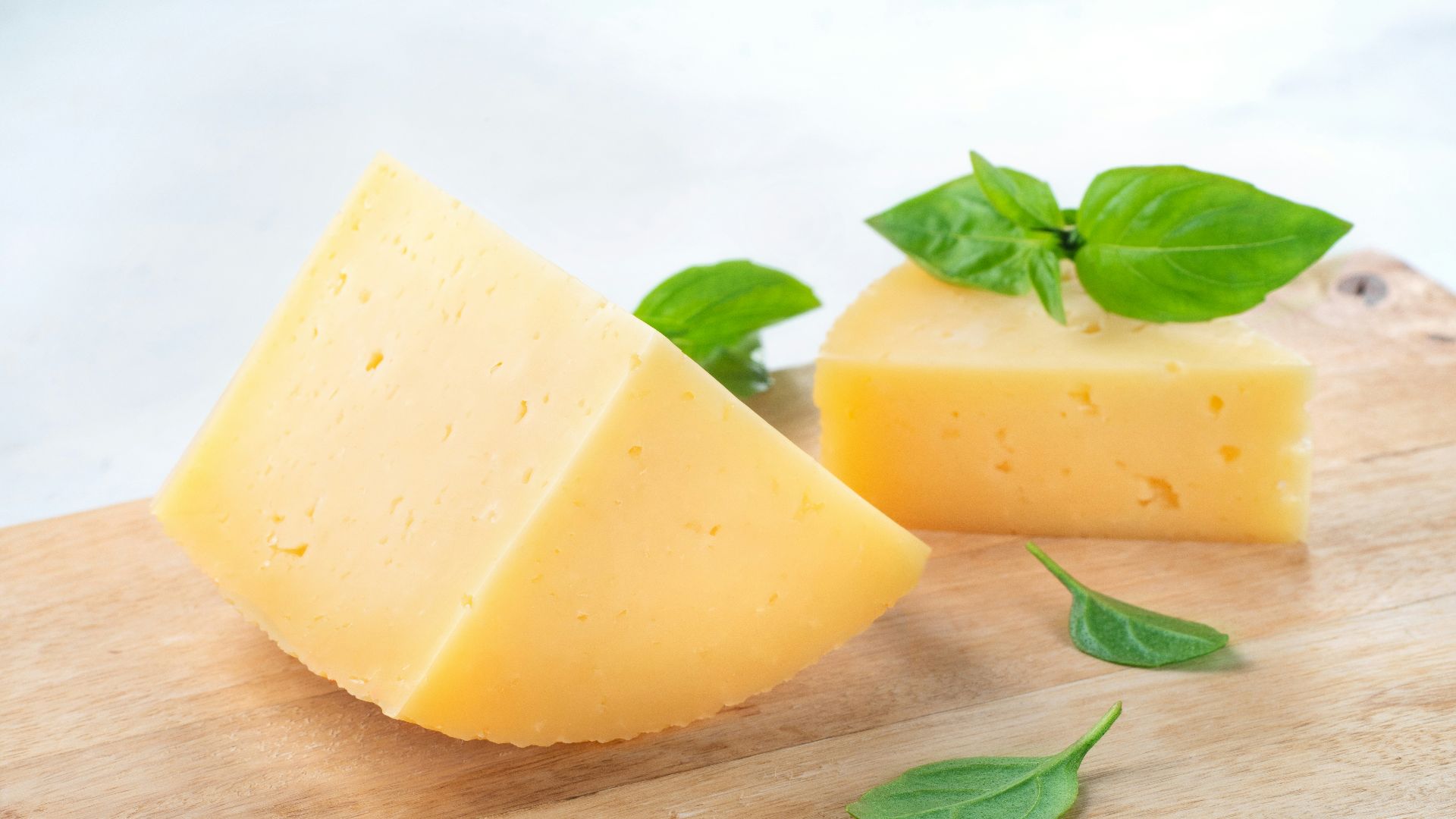 a piece of cheese with a leaf on top of it