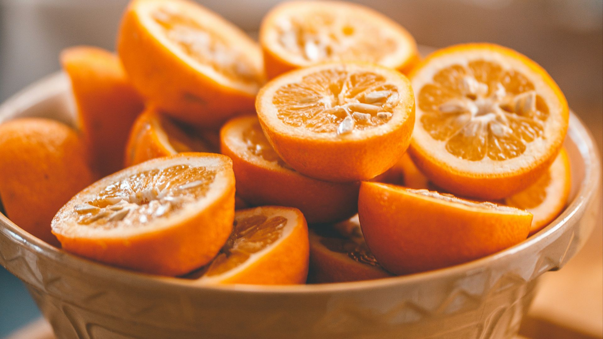 a bowl of oranges sitting on a table