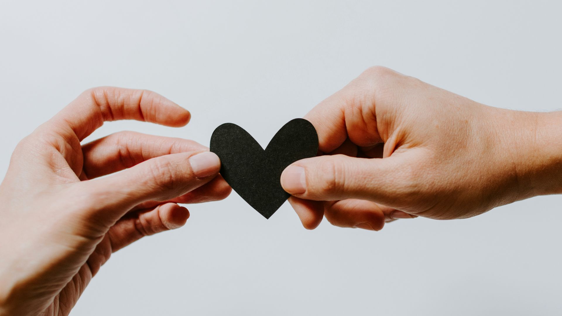 two person holding papercut heart