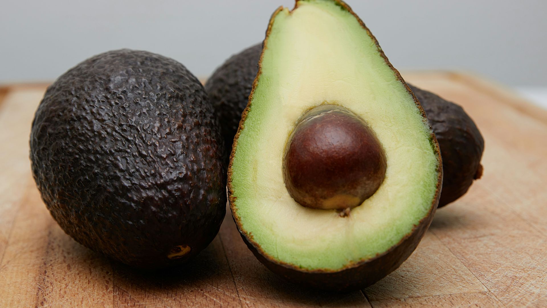sliced avocado fruit on brown wooden table