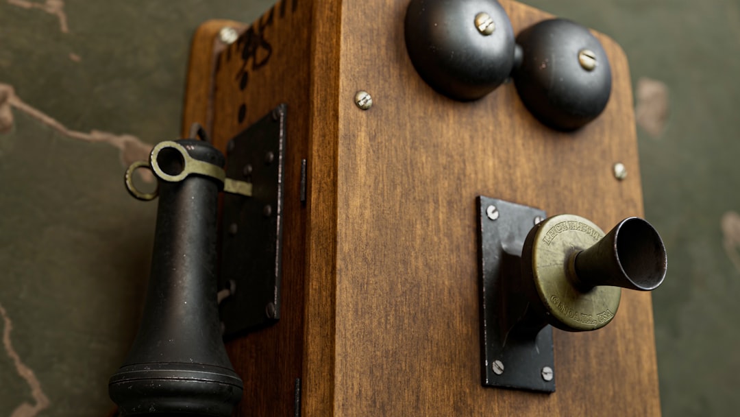 An old fashioned phone is on a wooden stand