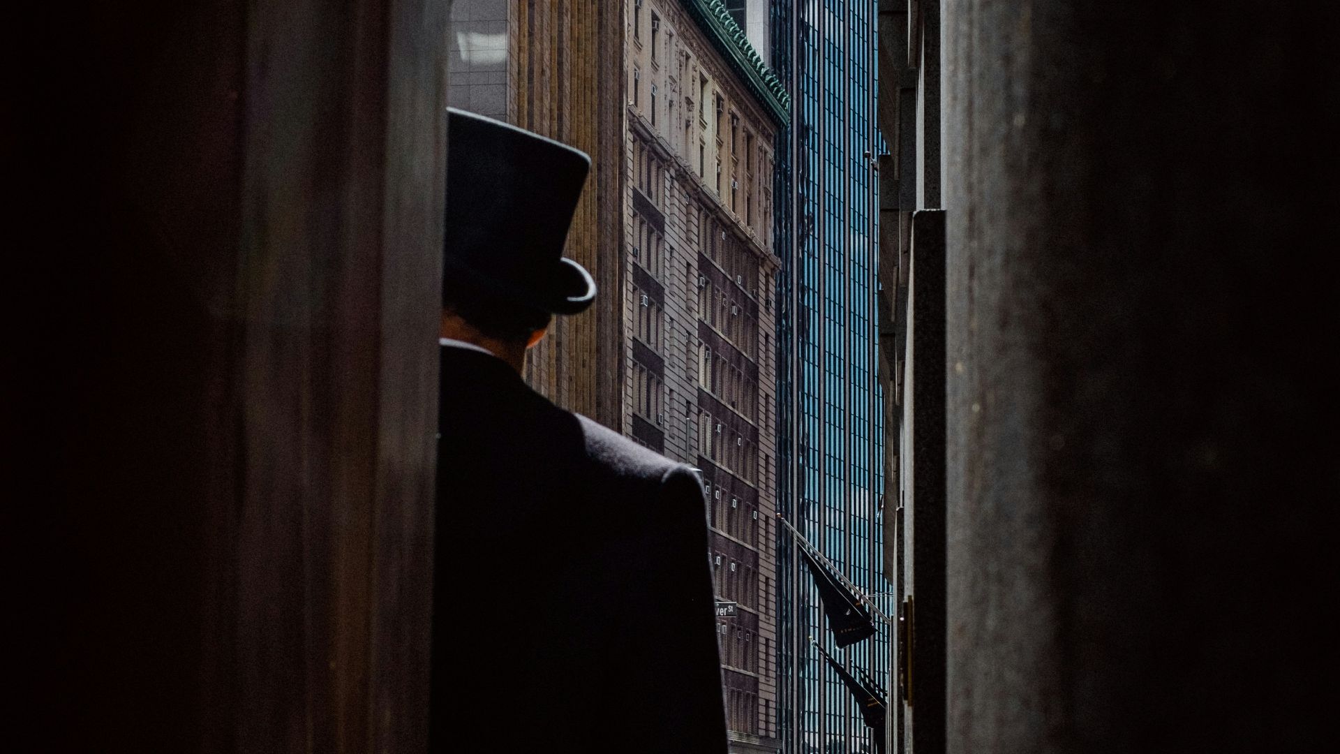 man wearing top hat standing near buildings