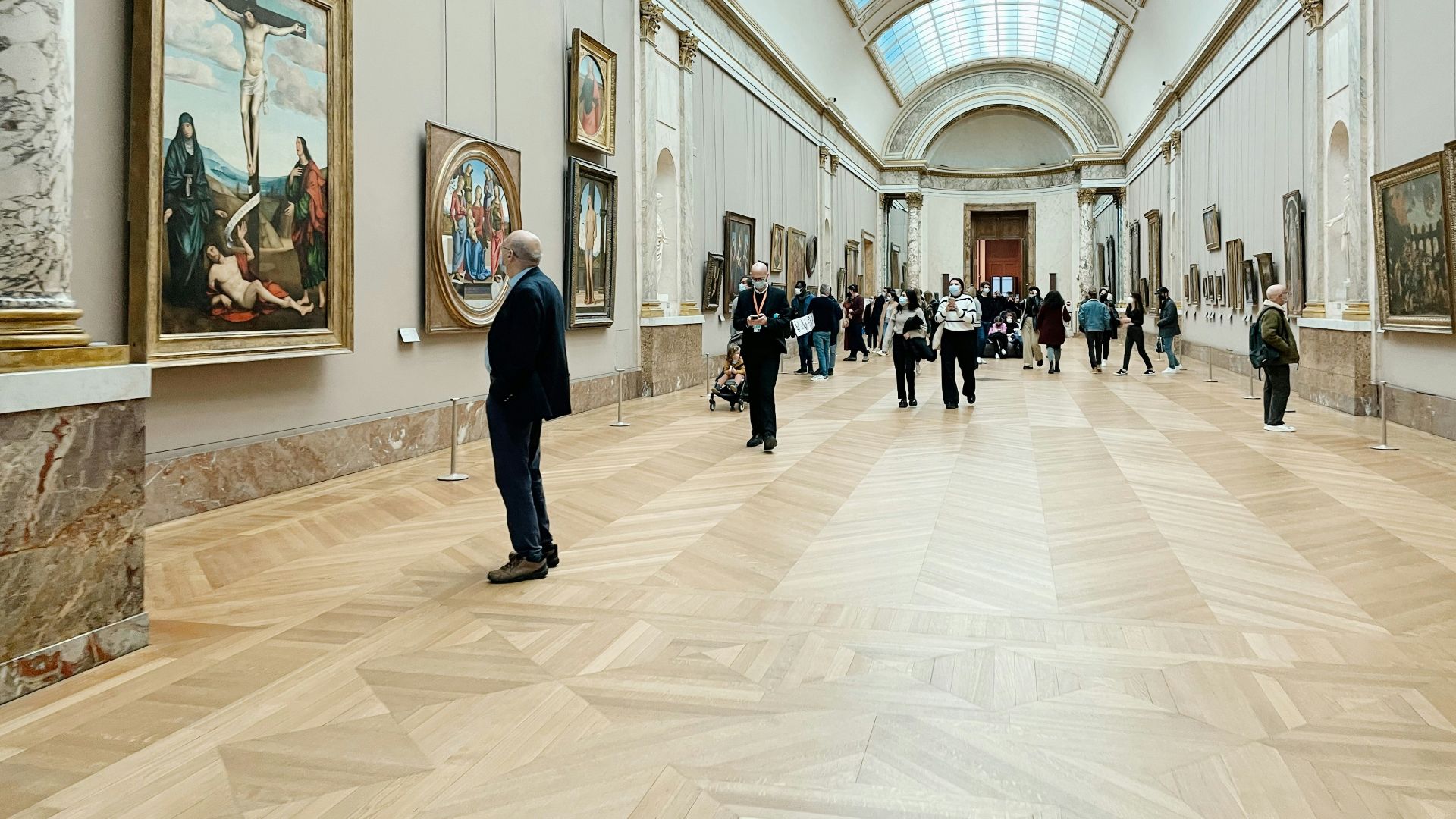 a group of people standing in a room with paintings on the walls