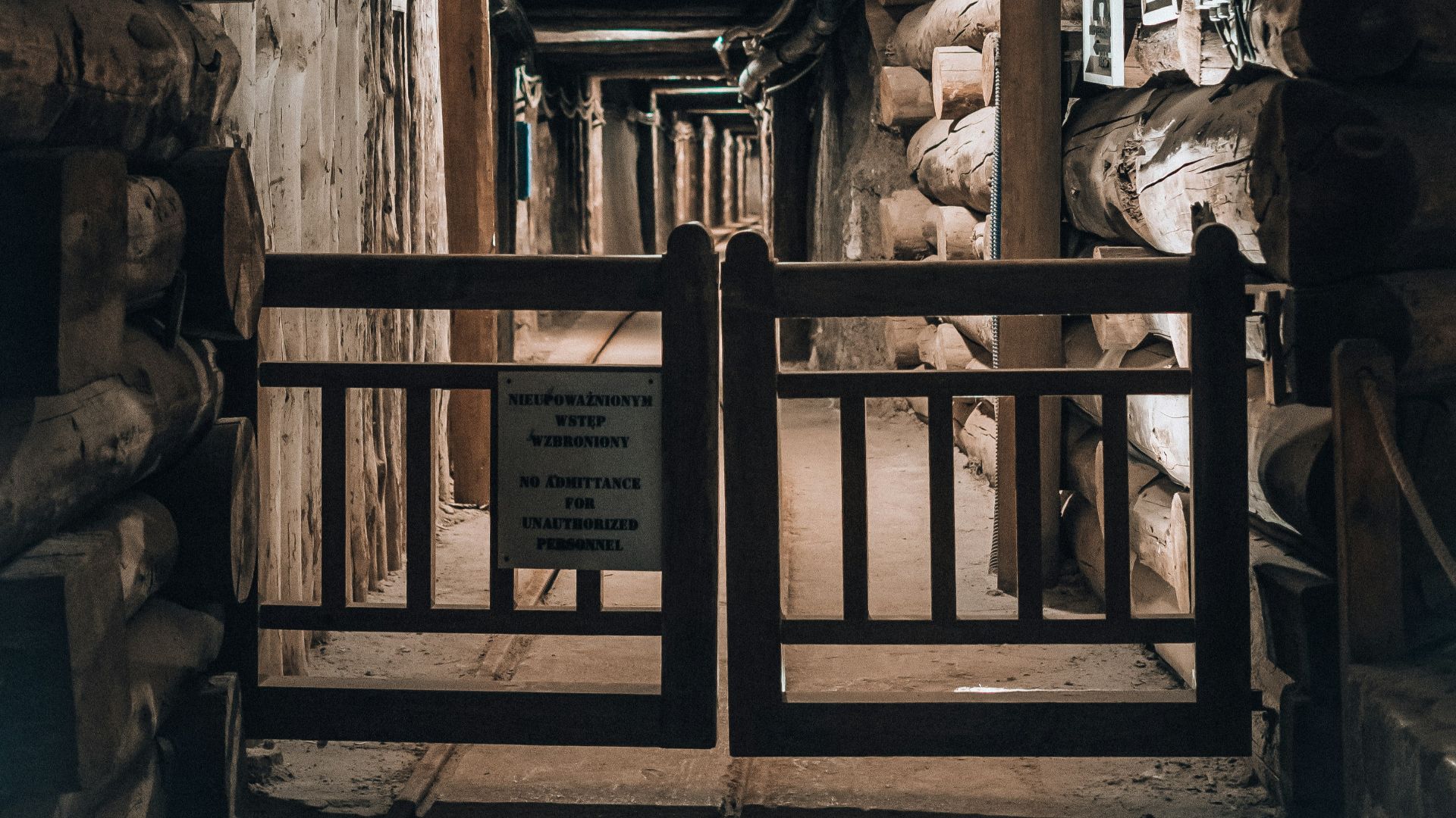 a wooden walkway with a sign on the side of it