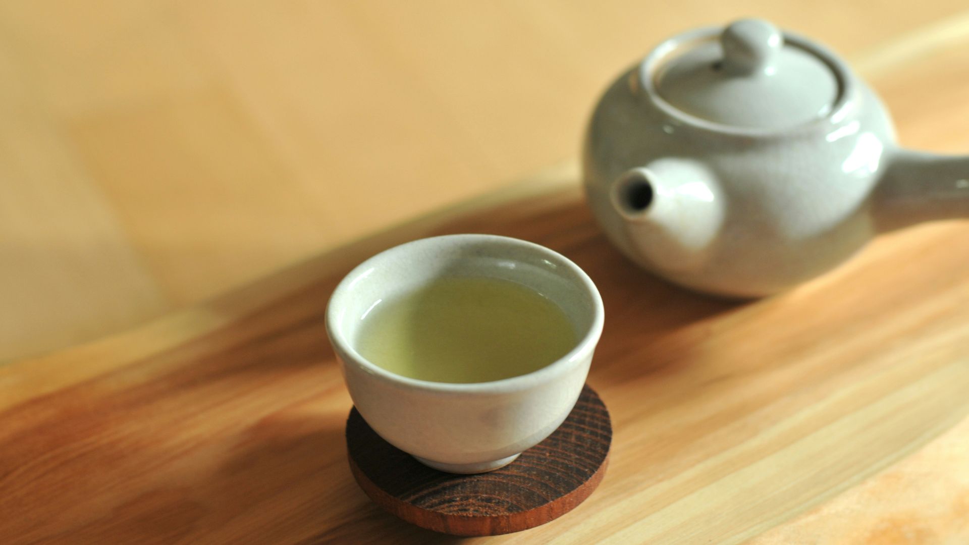 white ceramic teacup on brown wooden table