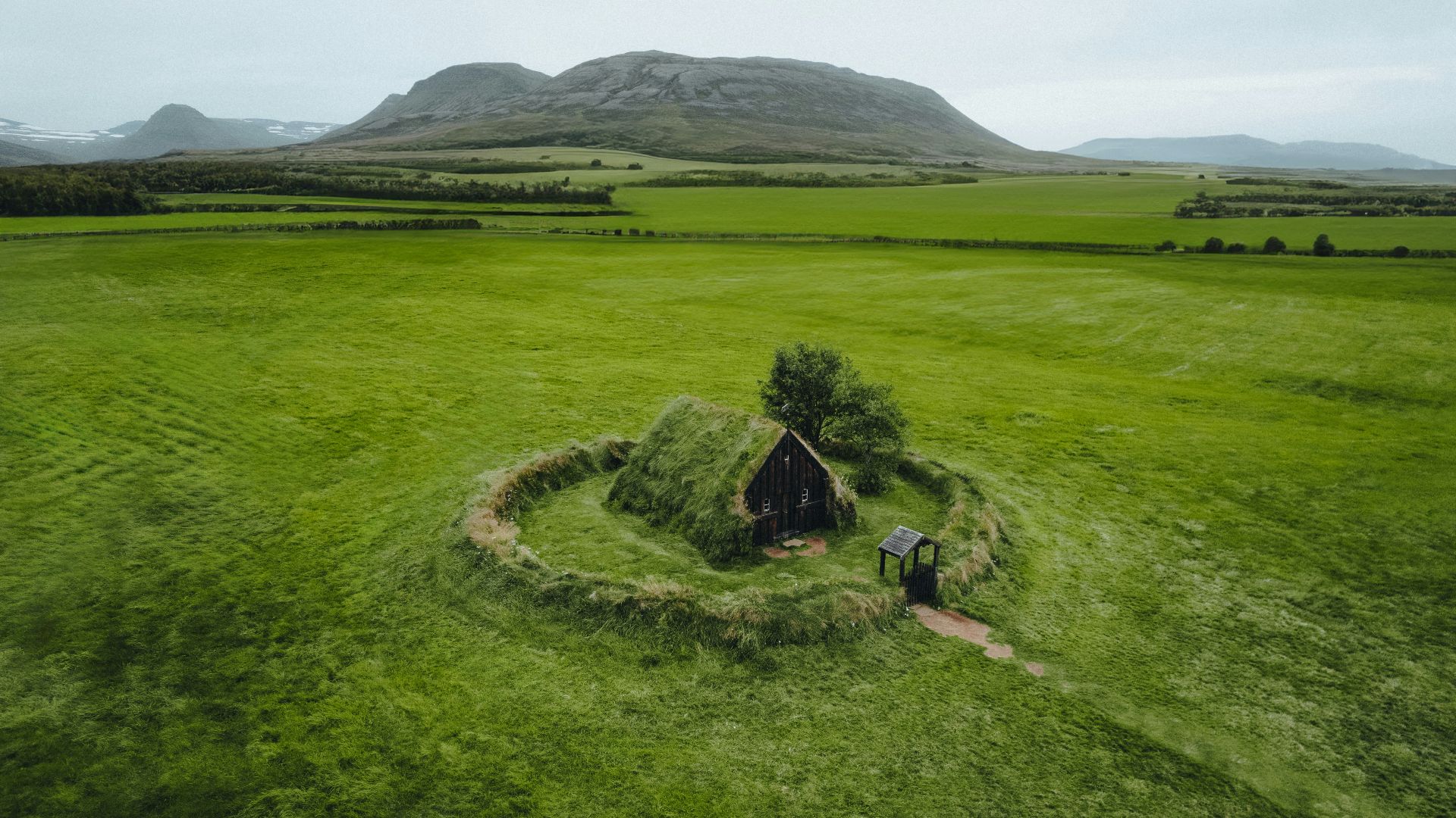 an aerial view of a small house in a field