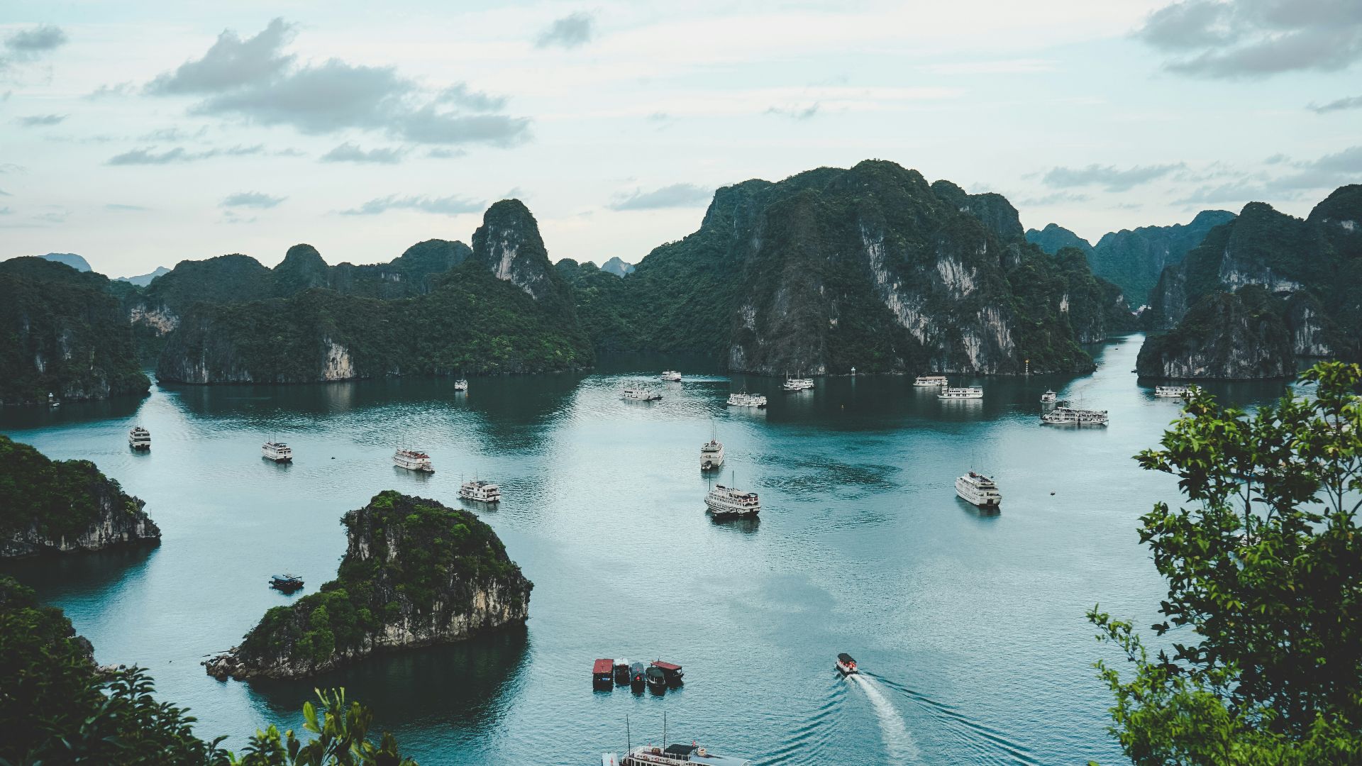 high-angle photography of boats on water near hill during daytime