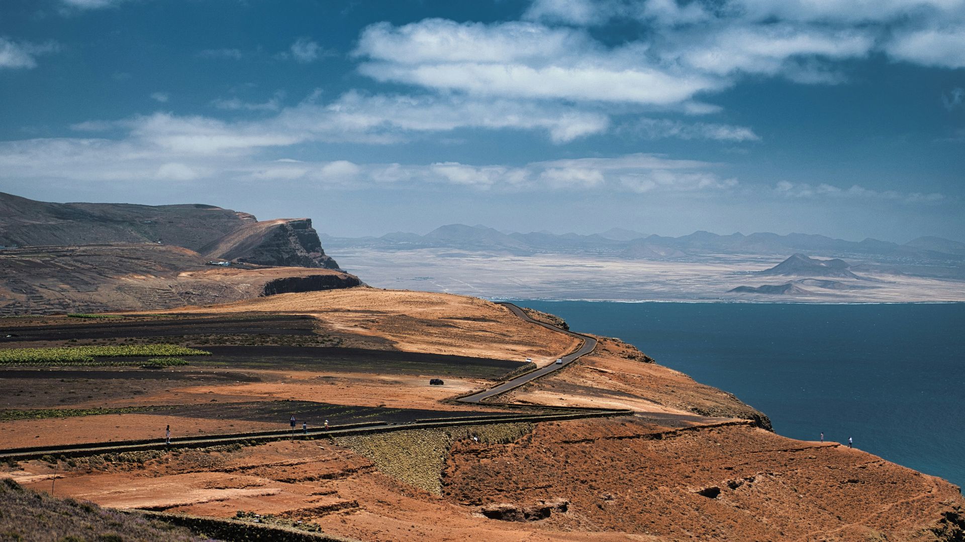 a large body of water sitting next to a rocky hillside