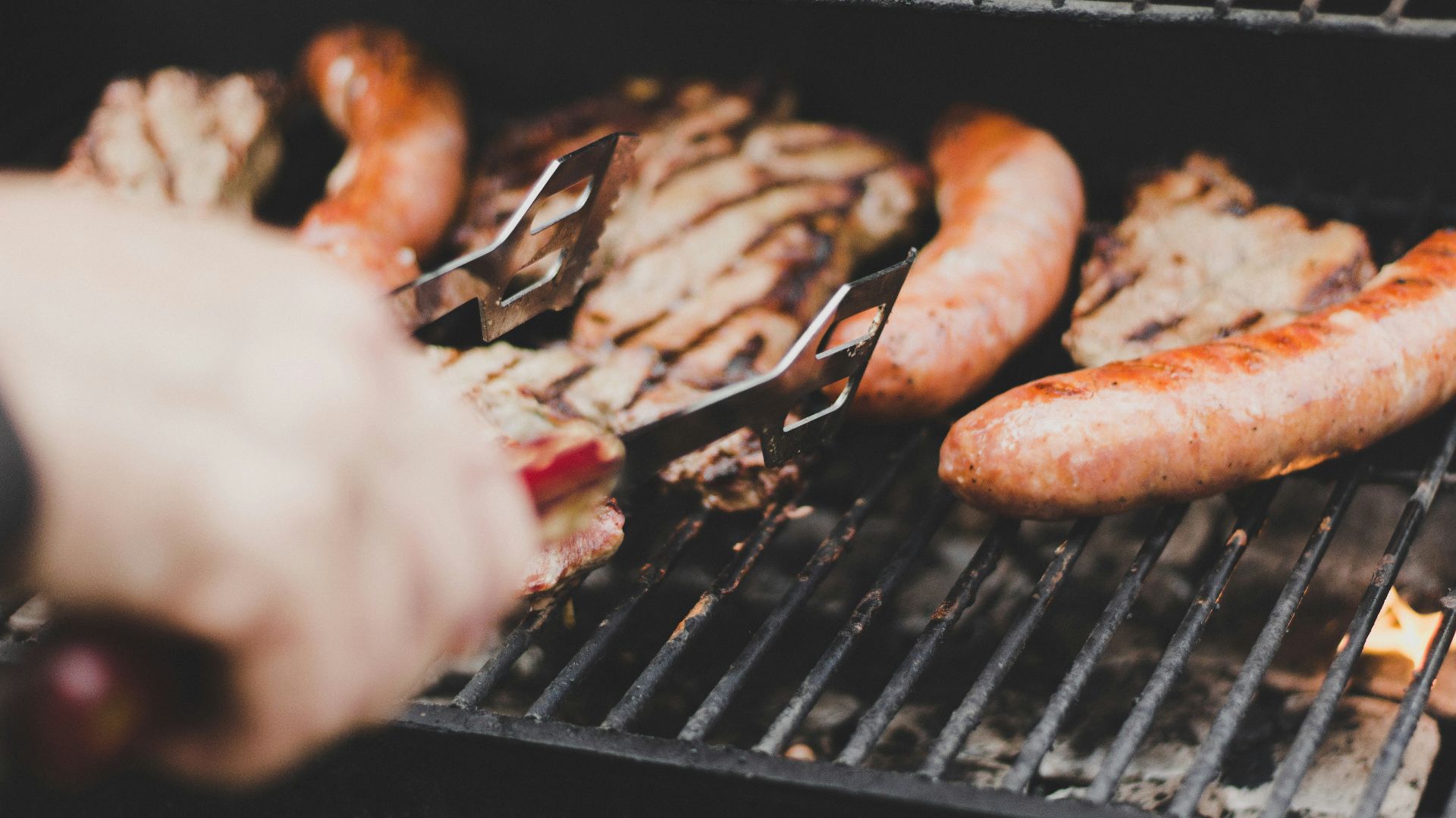 person grilling sausage and meat