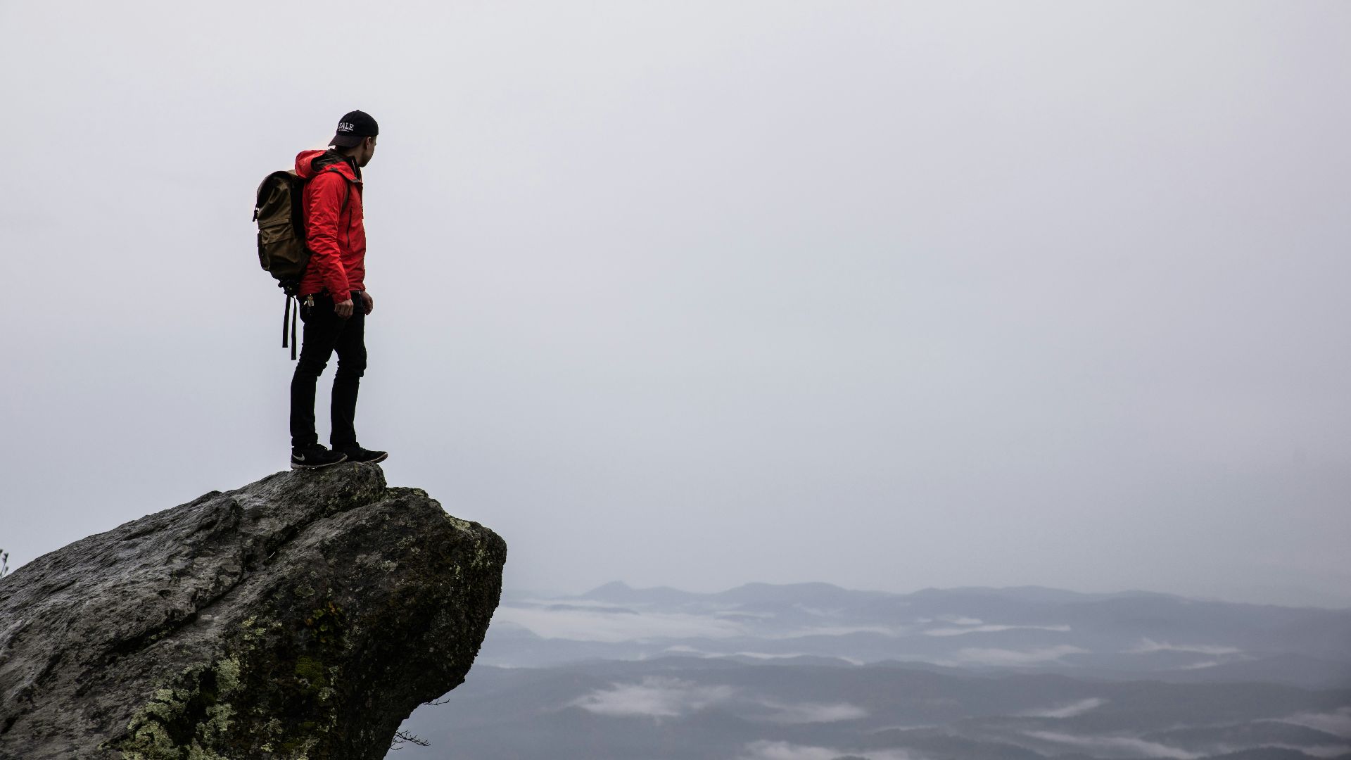 person standing on gray rock