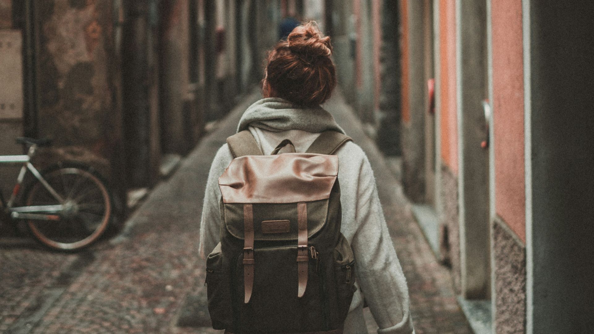 woman walking on street surrounded by buildings