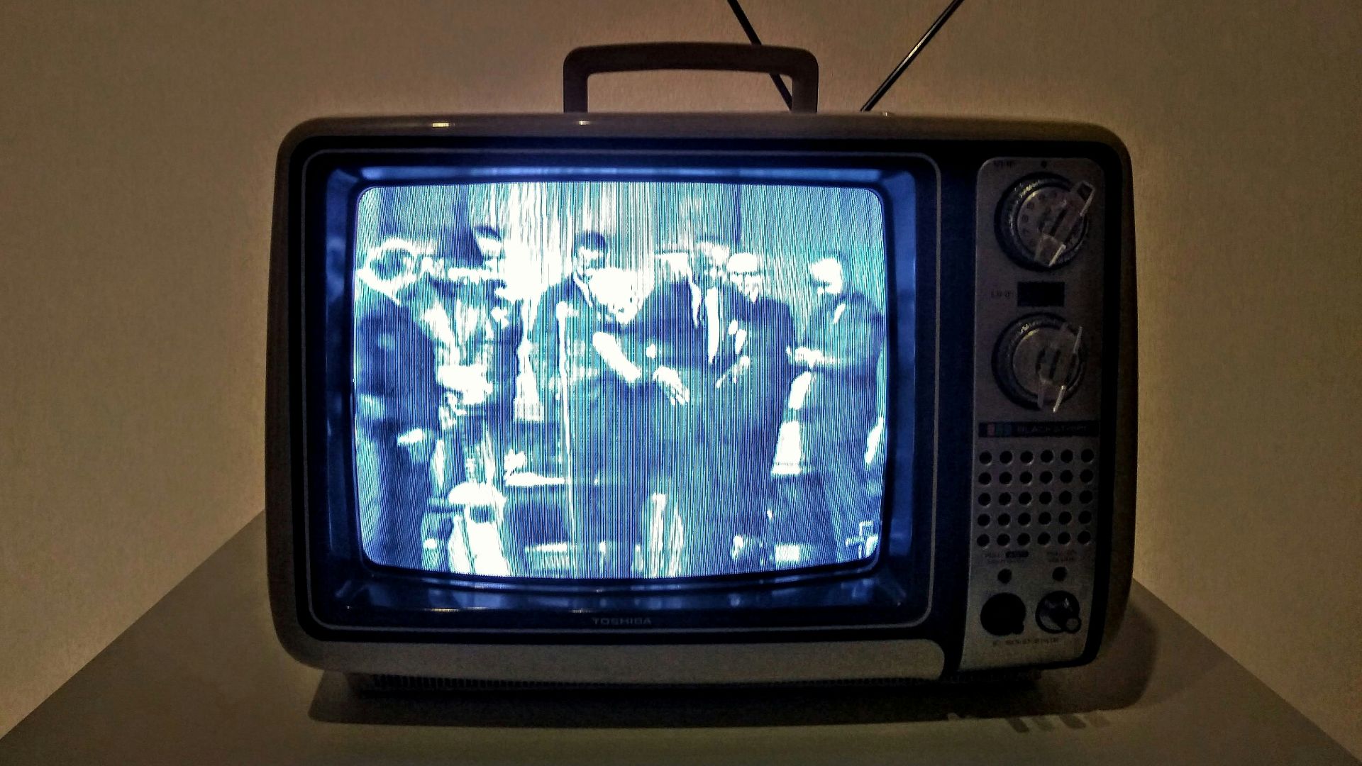 black crt tv turned on on white table