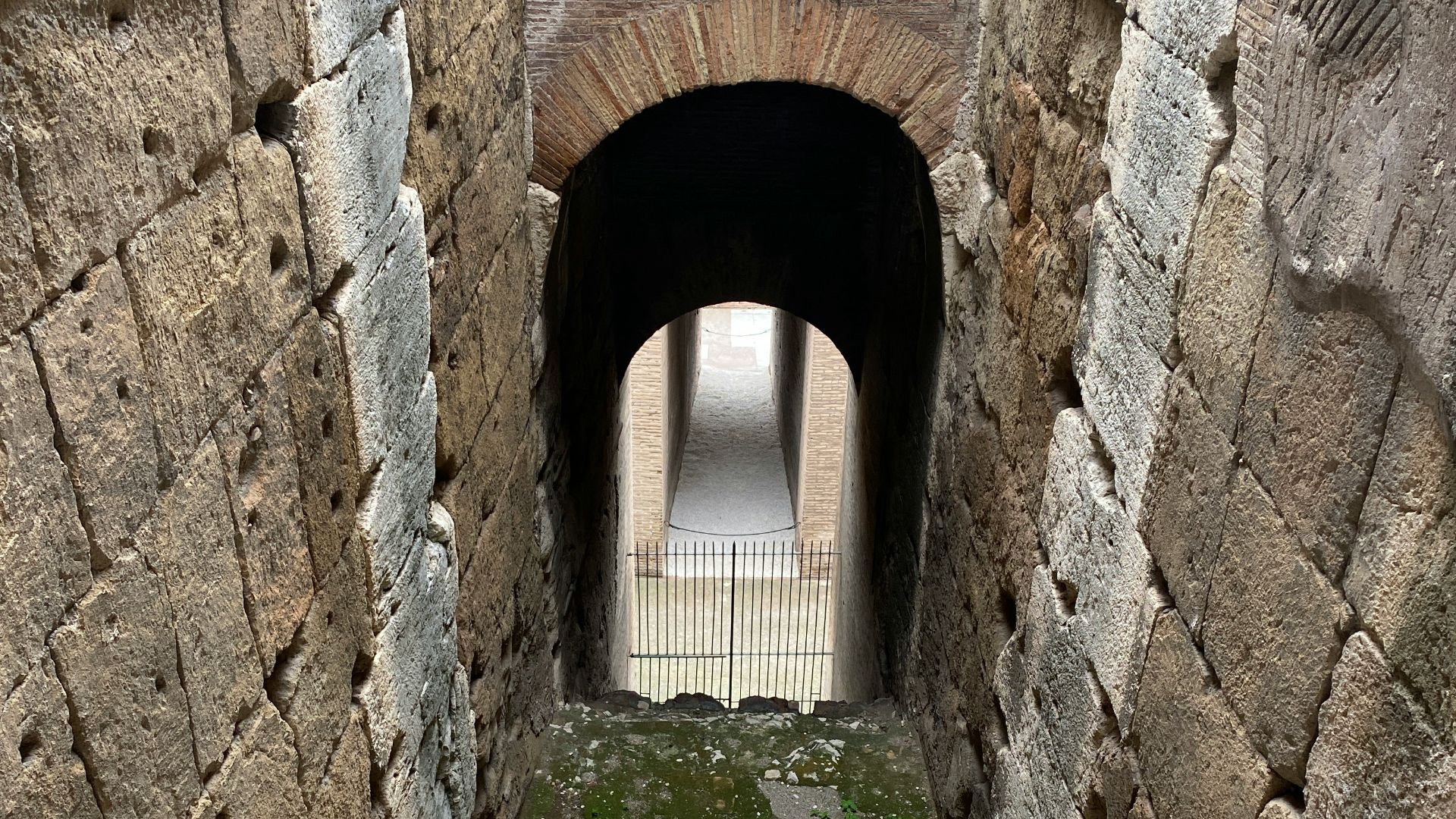 a stone tunnel with a walkway going through it
