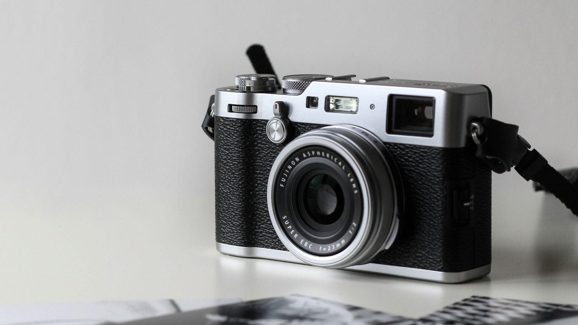 black and gray film camera near printed photos