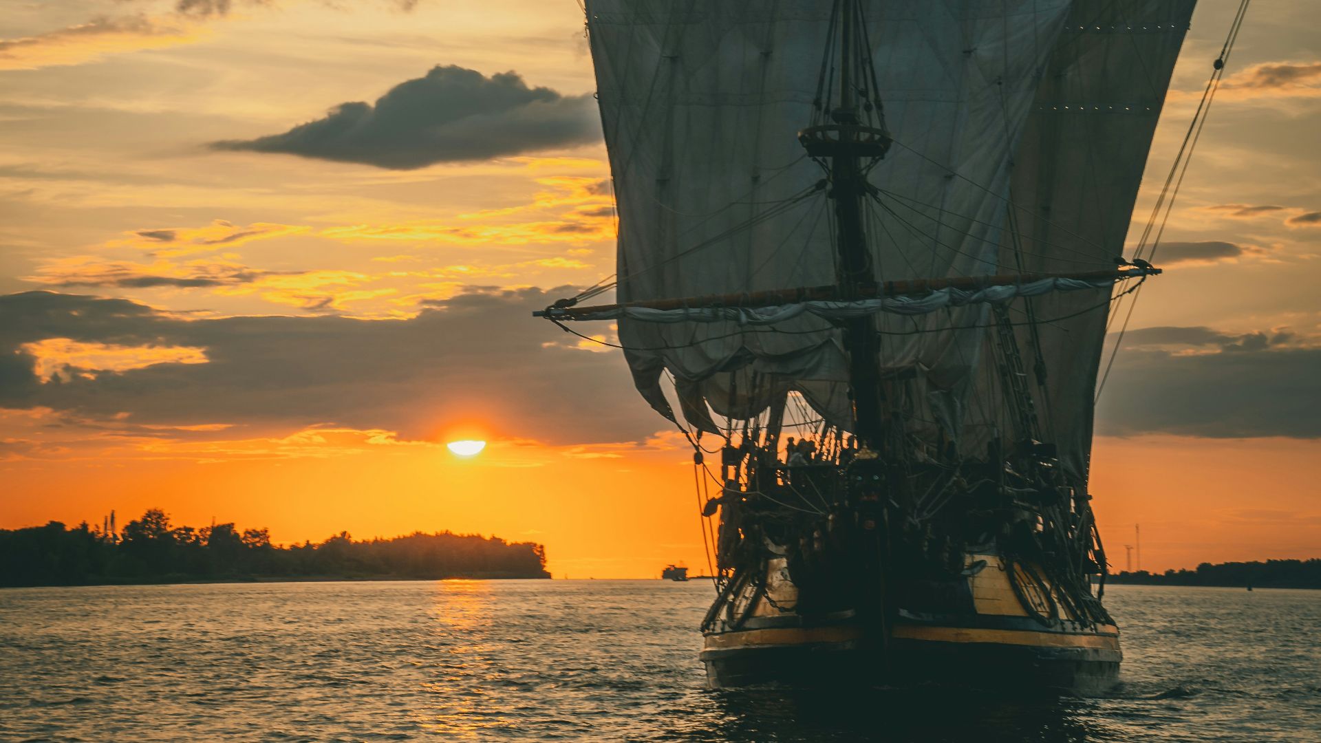 silhouette of ship on sea during sunset