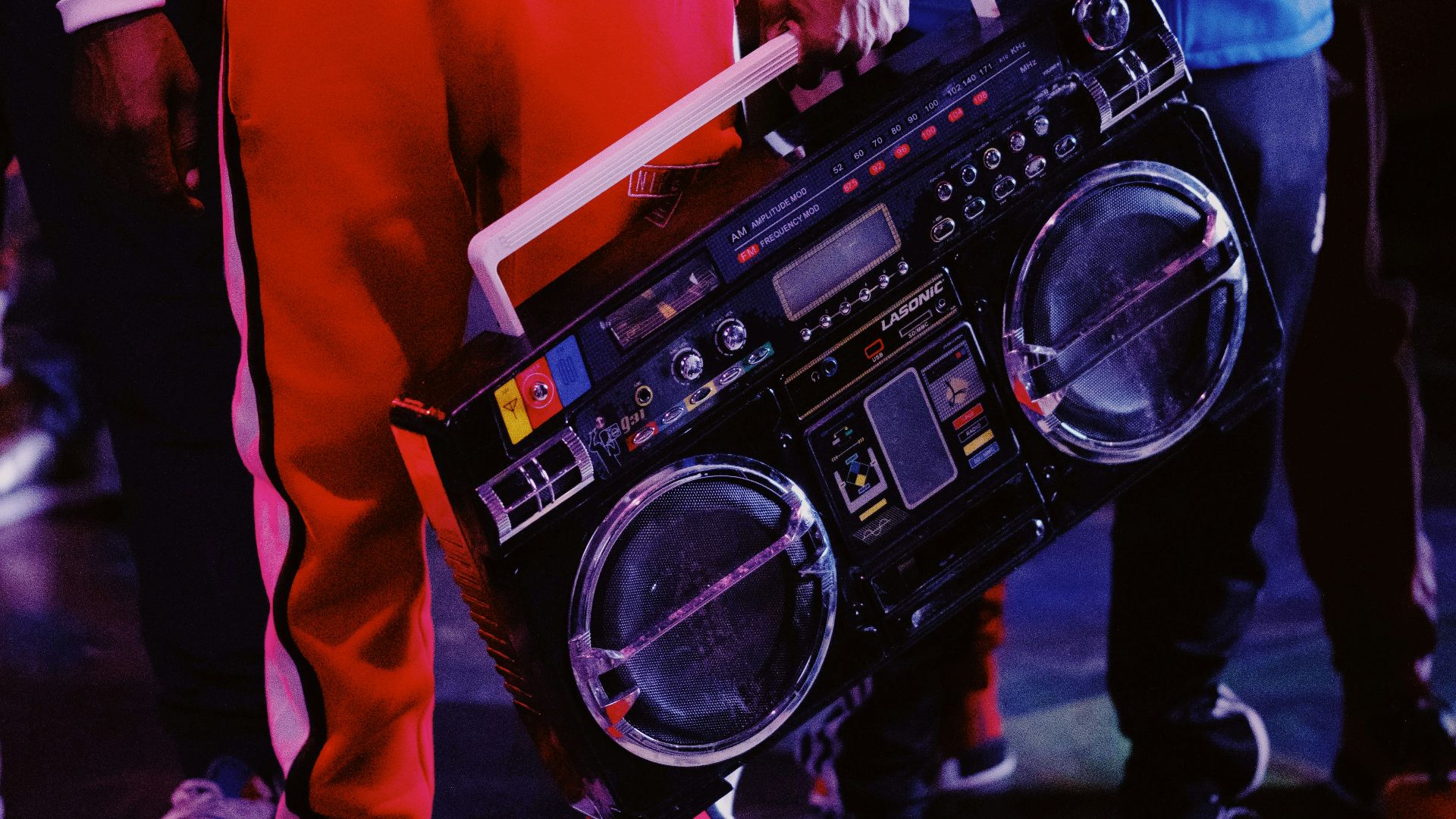 man in red jacket holding black dj controller