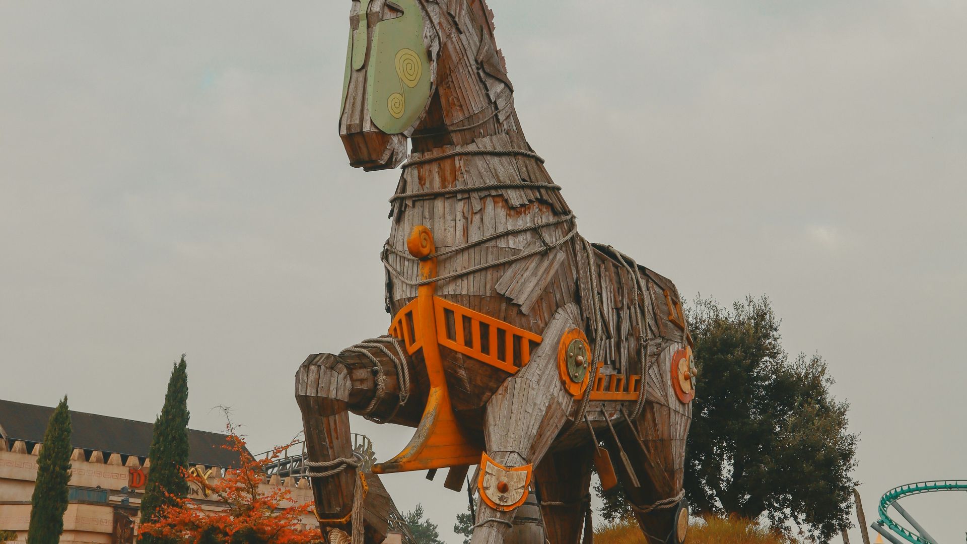 a large wooden horse statue sitting on top of a dirt field