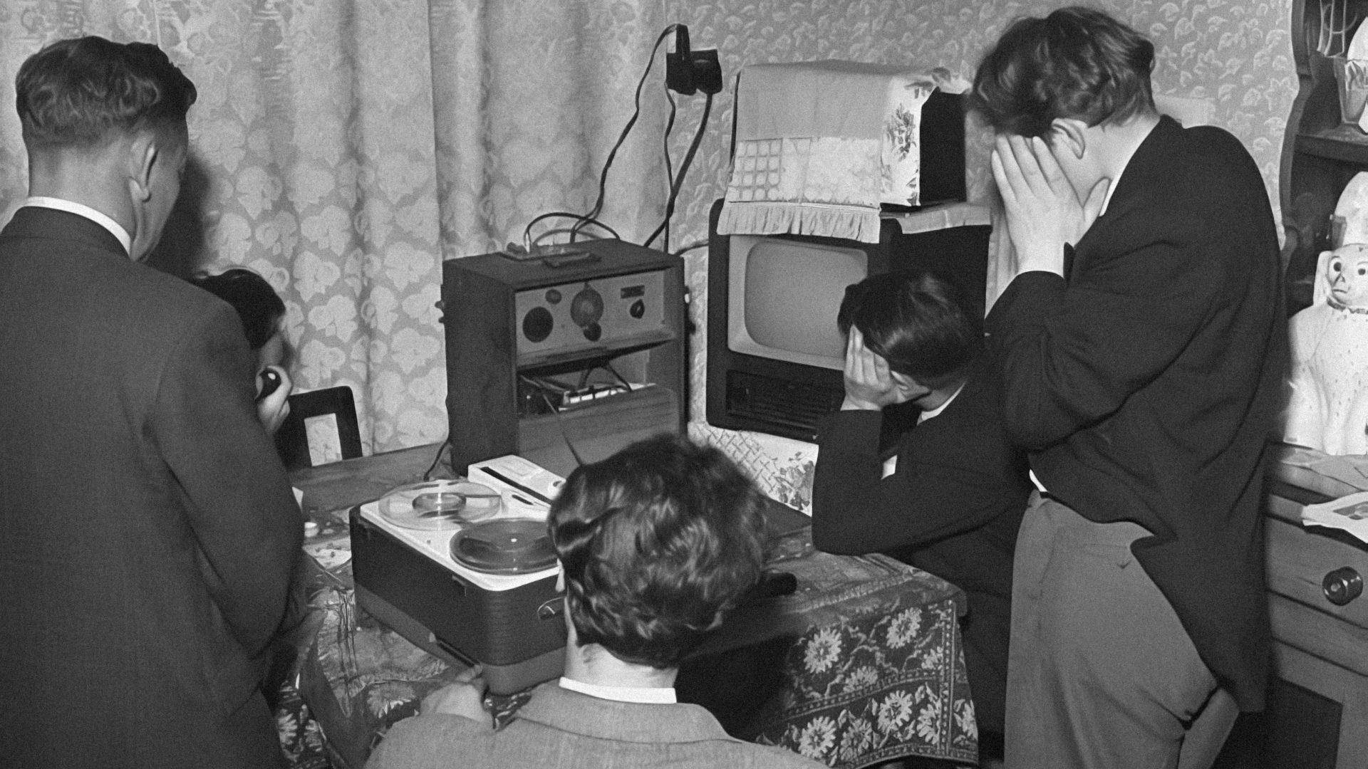 a black and white photo of people in a living room