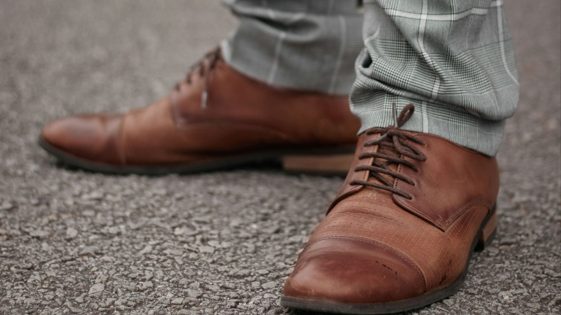 person in gray denim jeans and brown leather shoes