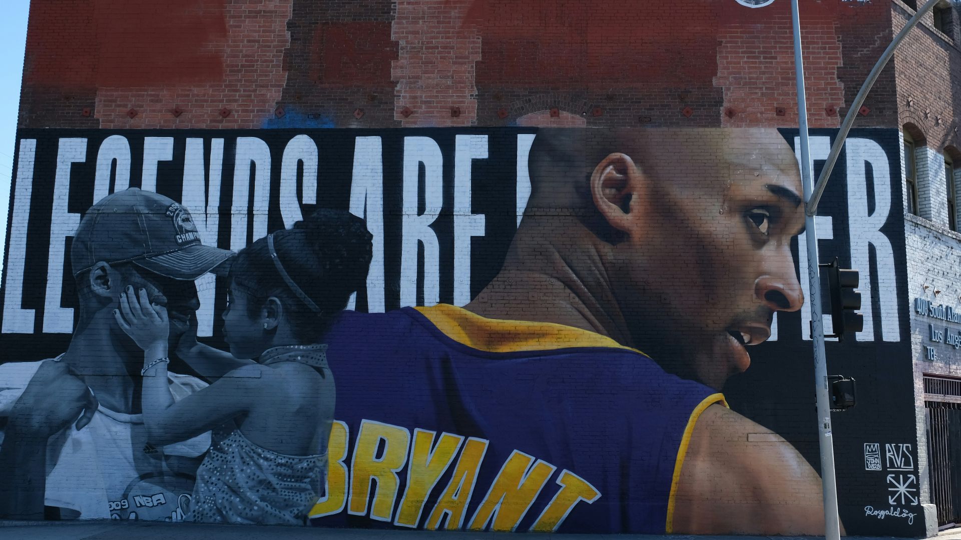 man in yellow and blue tank top sitting on black metal bench