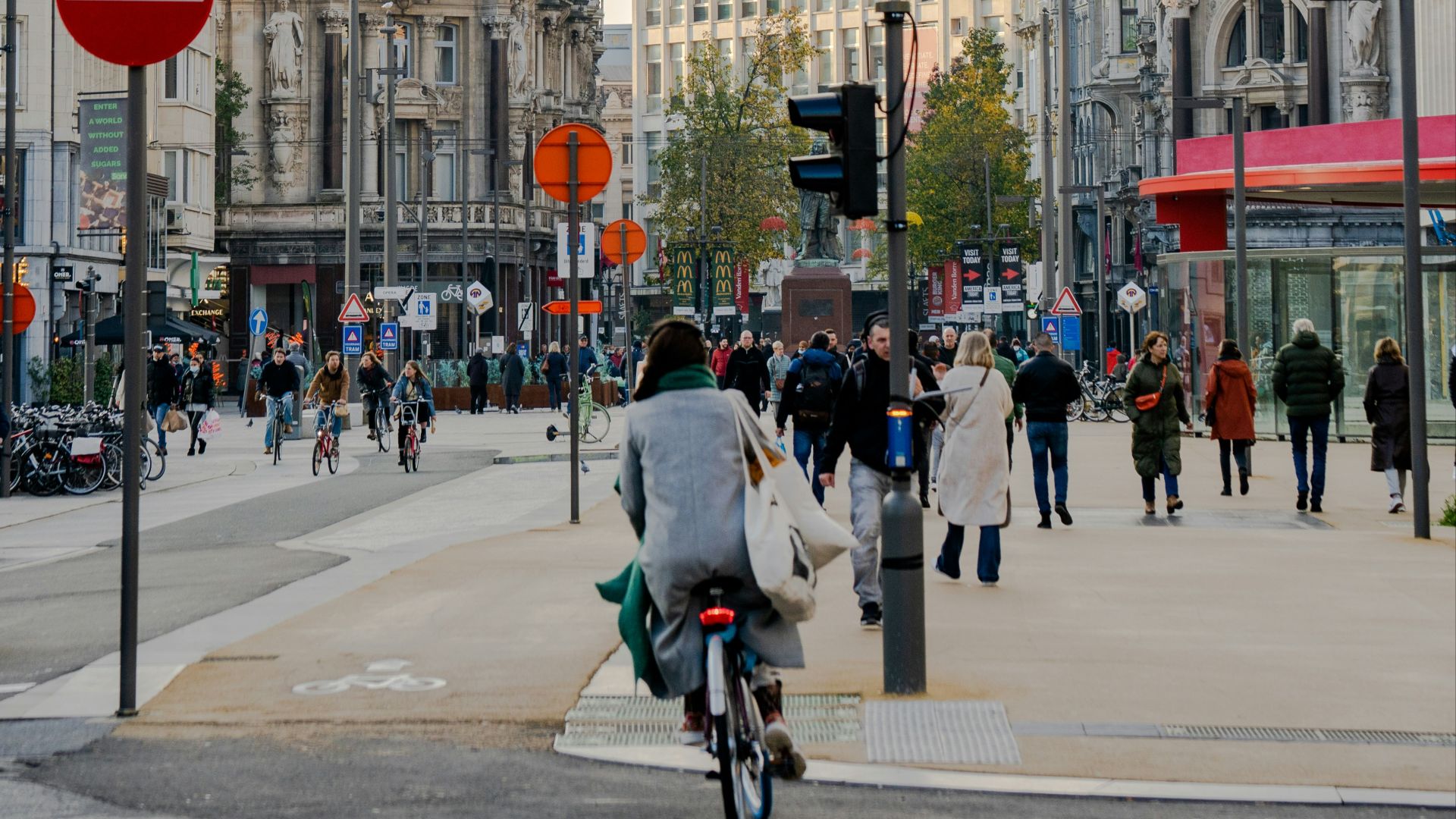a man riding a bike down a street next to tall buildings