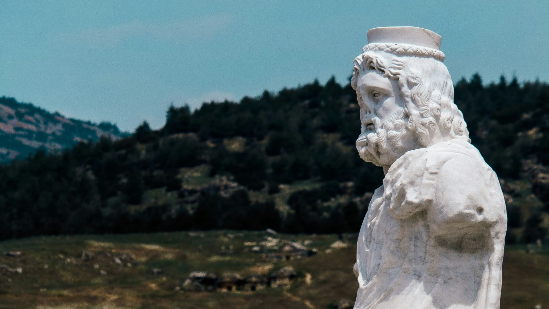 a statue of a man sitting on a bench next to a dog