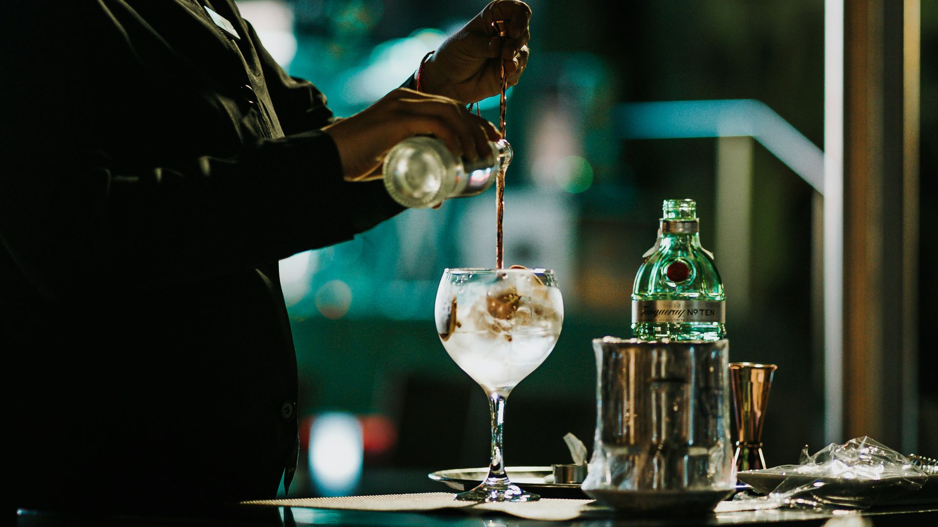 a person pouring a drink into a glass