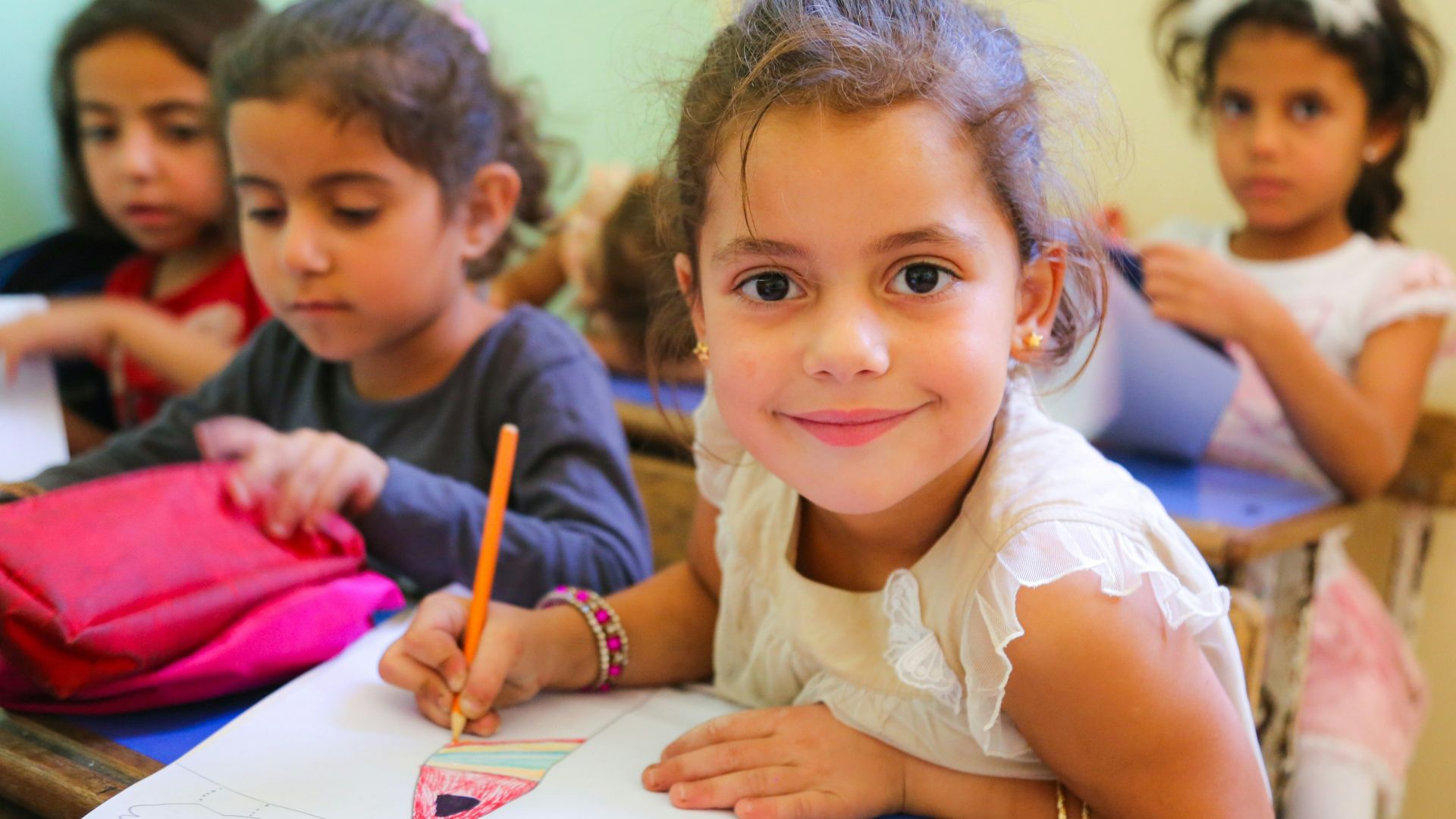 A group of young children sitting at a desk