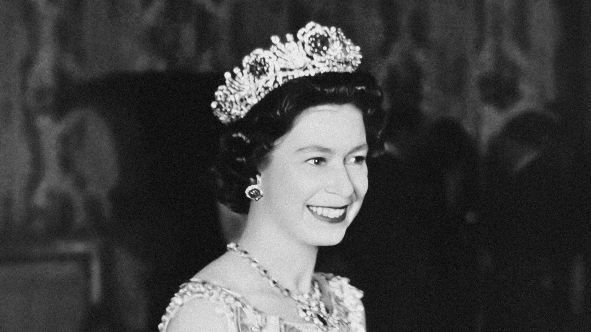 a black and white photo of a woman wearing a tiara