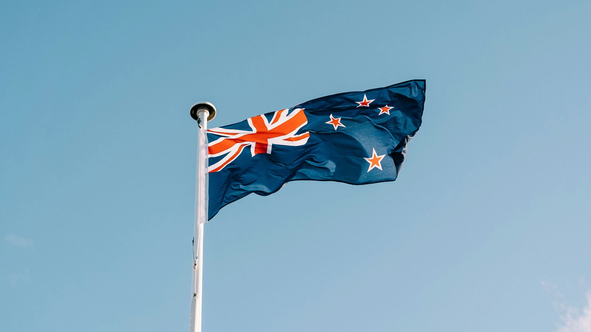 a flag flying in the wind on a clear day