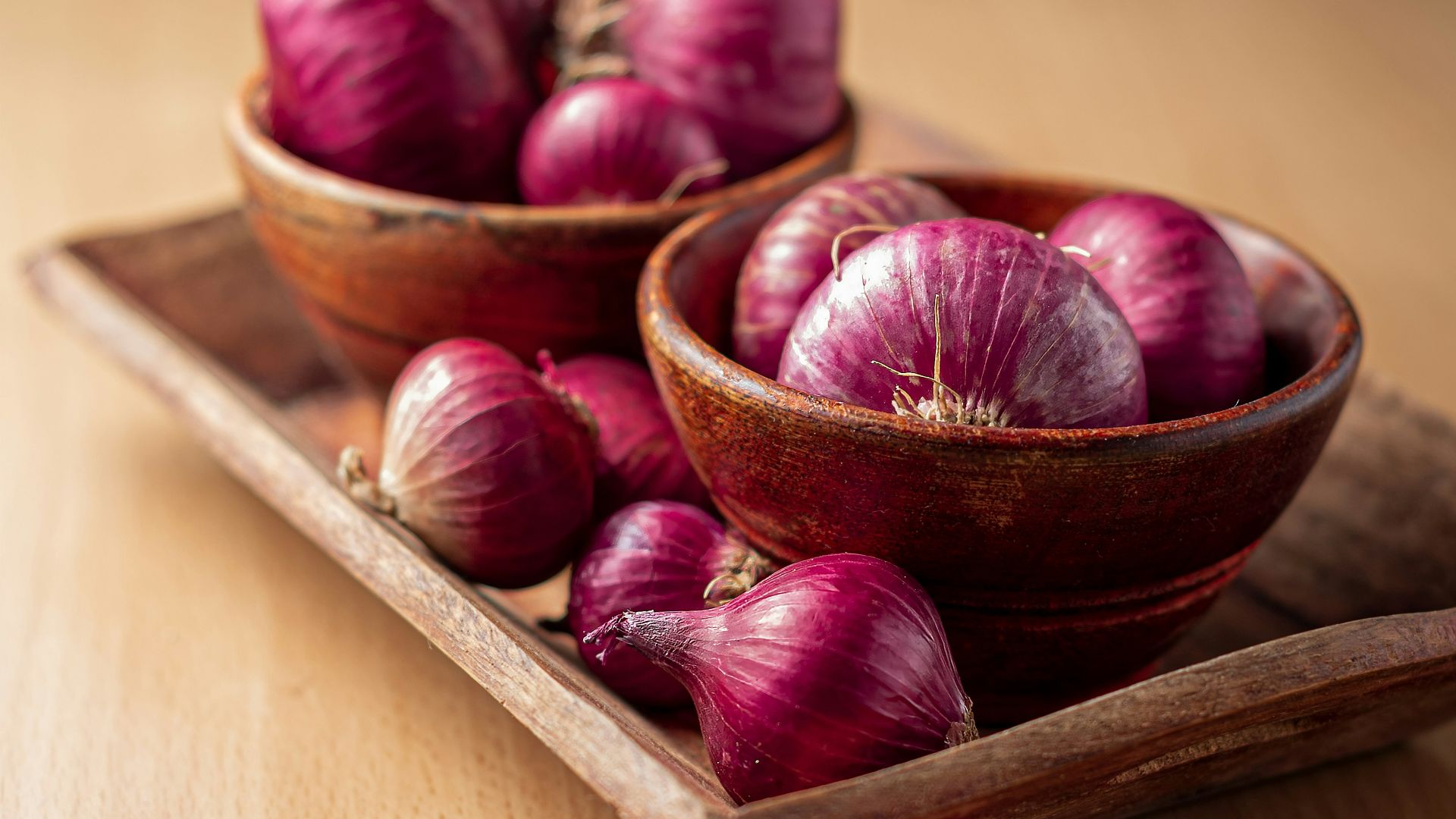red onion on brown wooden tray