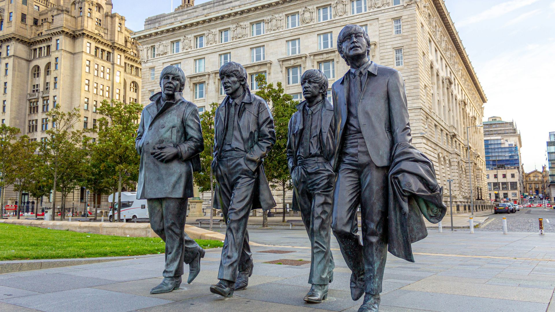 2 men in black coat standing near white concrete building during daytime