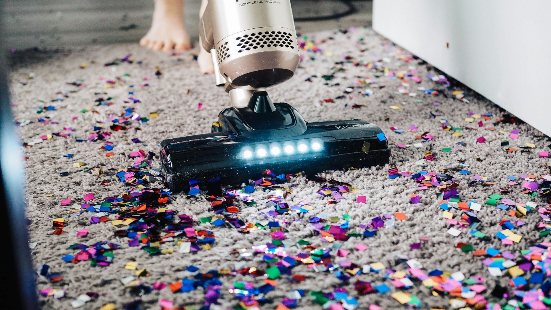 a person using a vacuum to clean a carpet