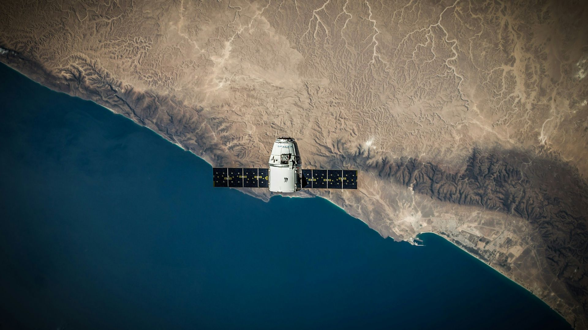A space satellite hovering above the coastline