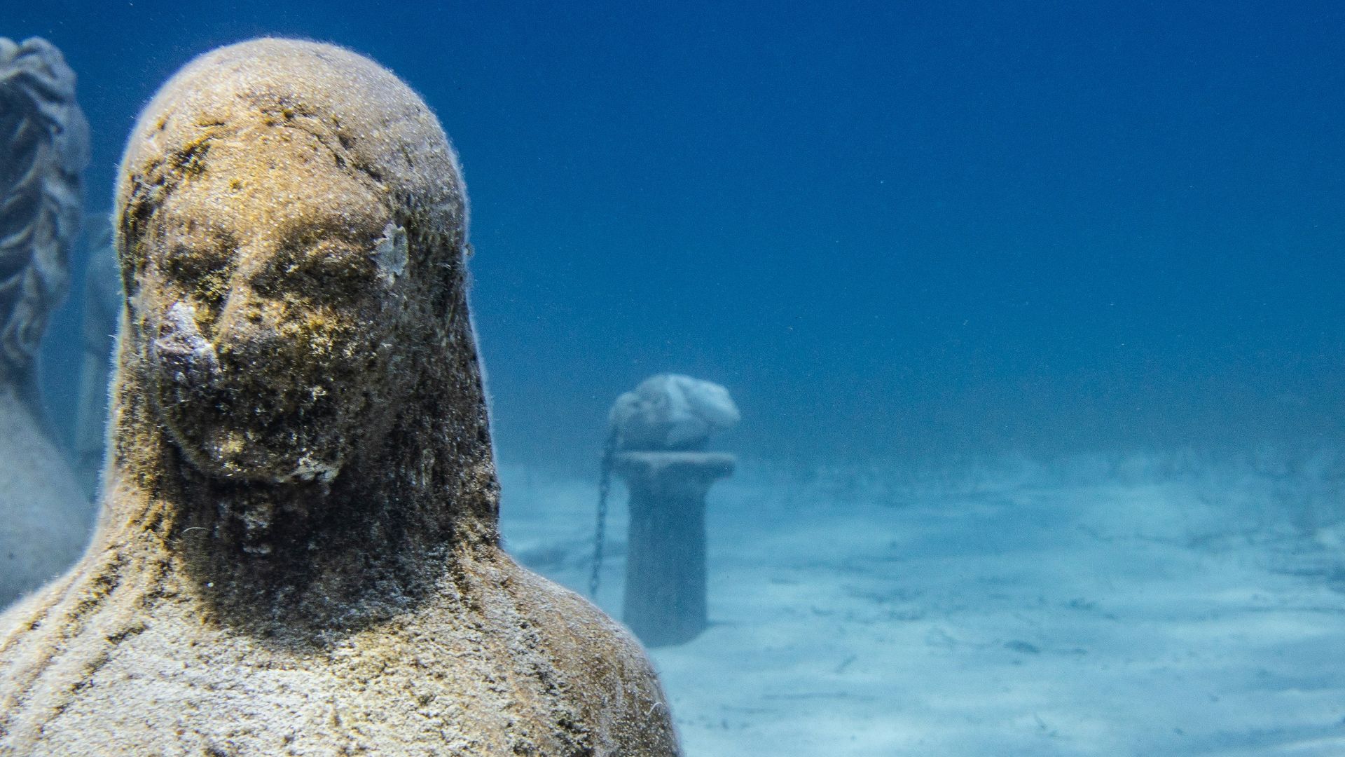 a statue of a man and a woman in the water