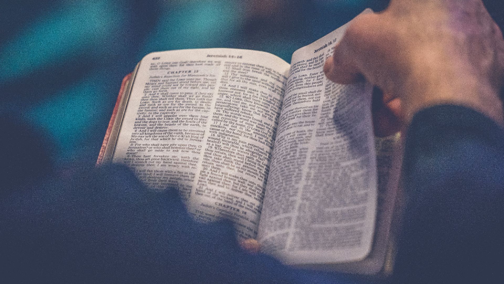 person's hand holding book page