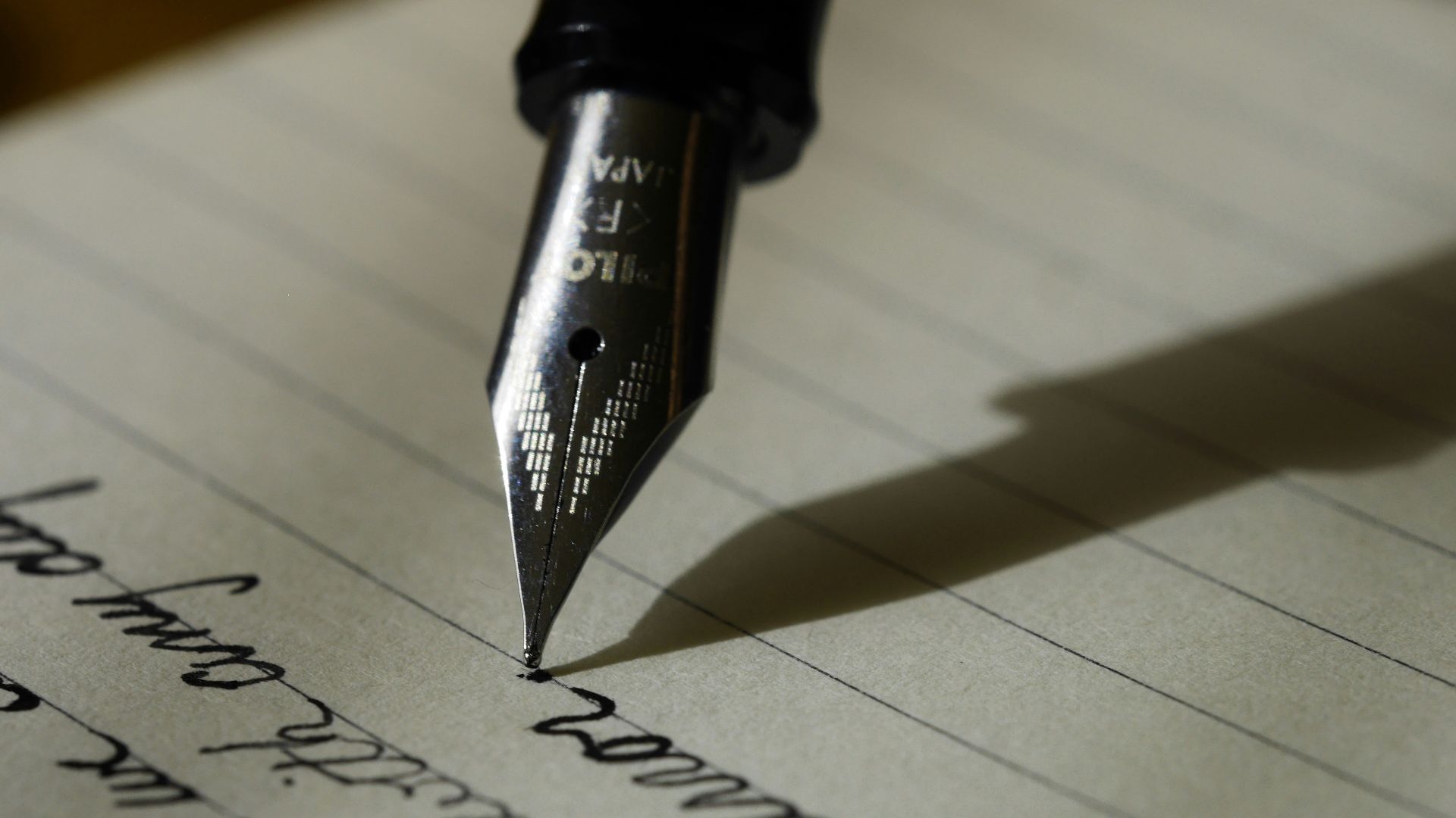 fountain pen on black lined paper