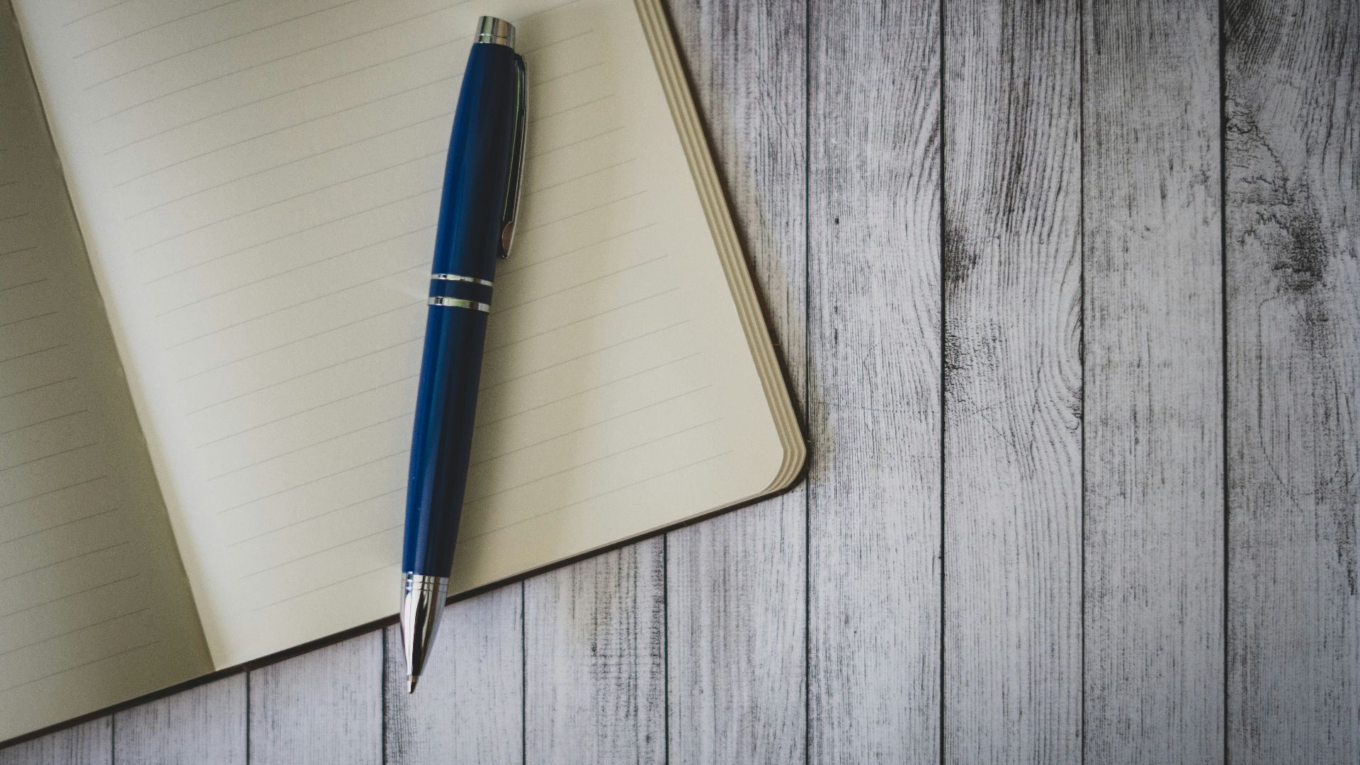 blue click pen on brown wooden table