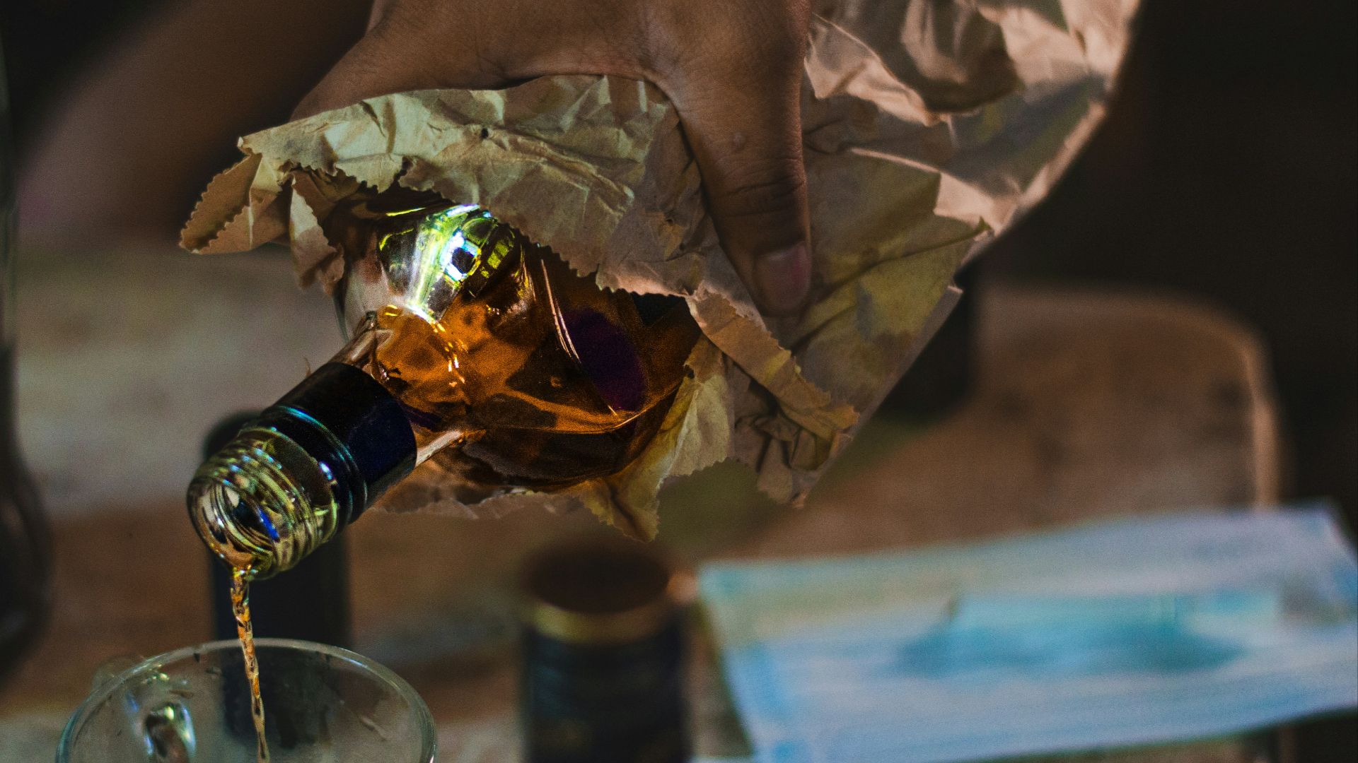 a person pouring a bottle of wine into a glass