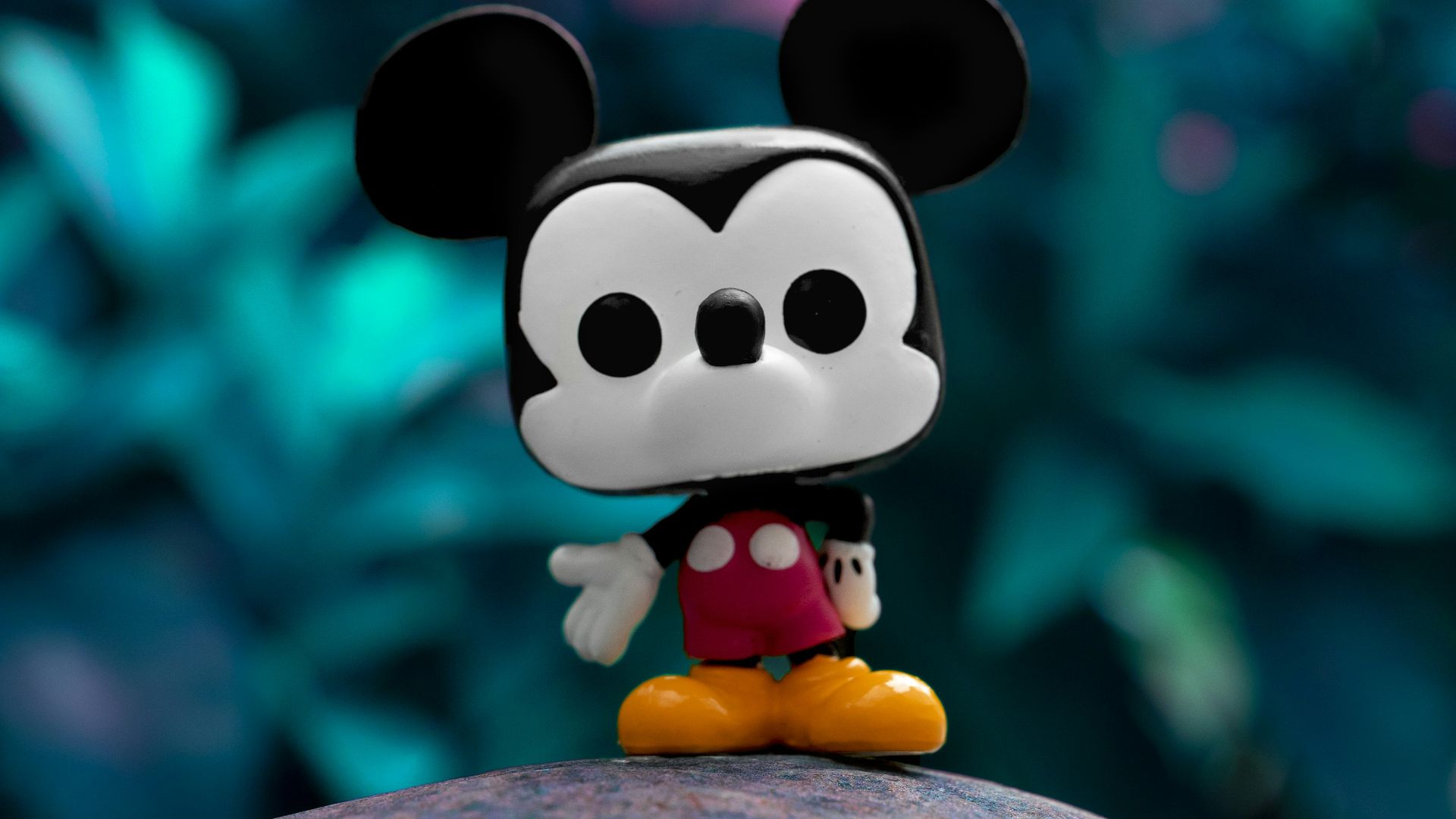 mickey mouse plush toy on gray rock