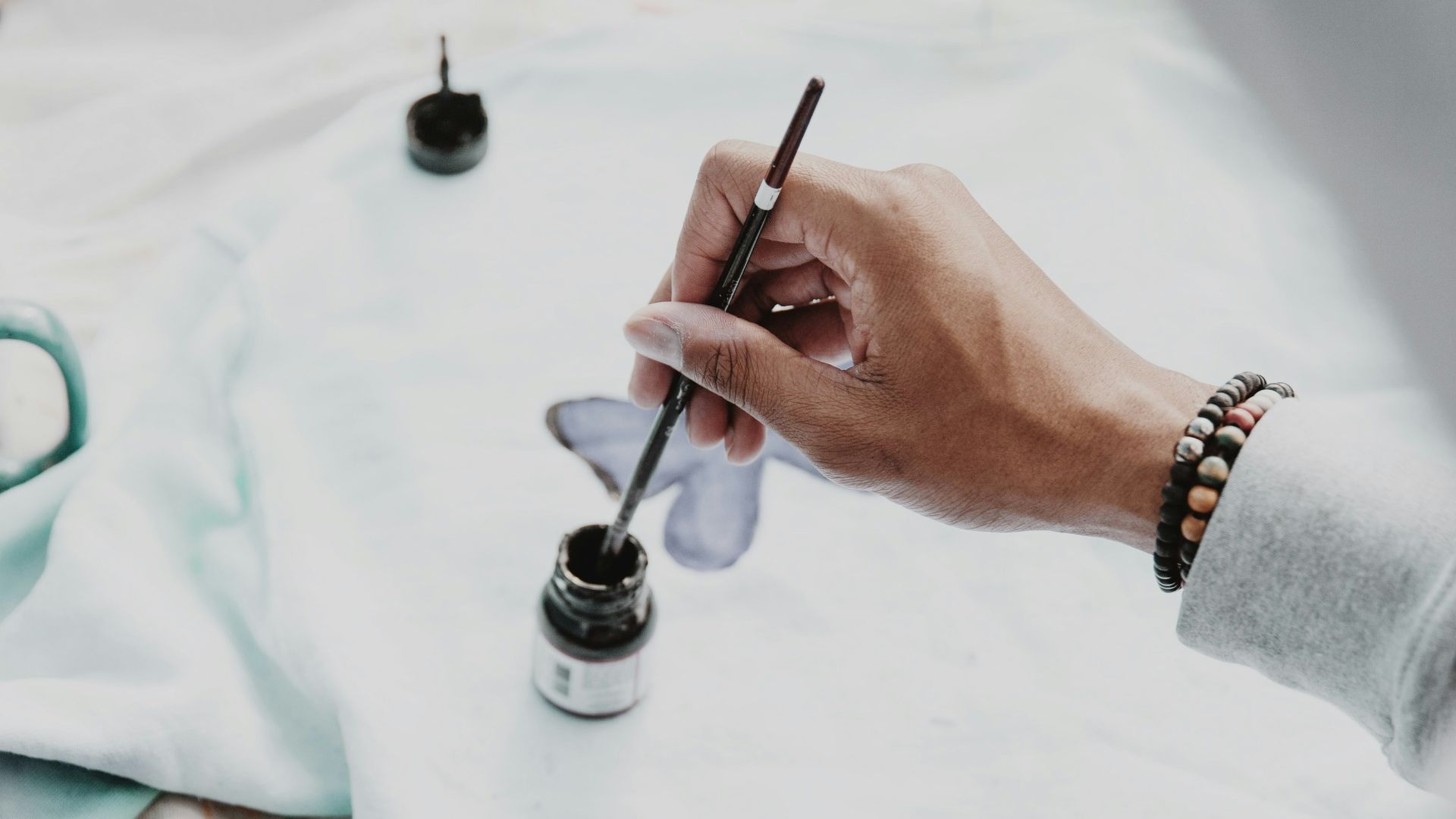 person holding pen and writing on paper